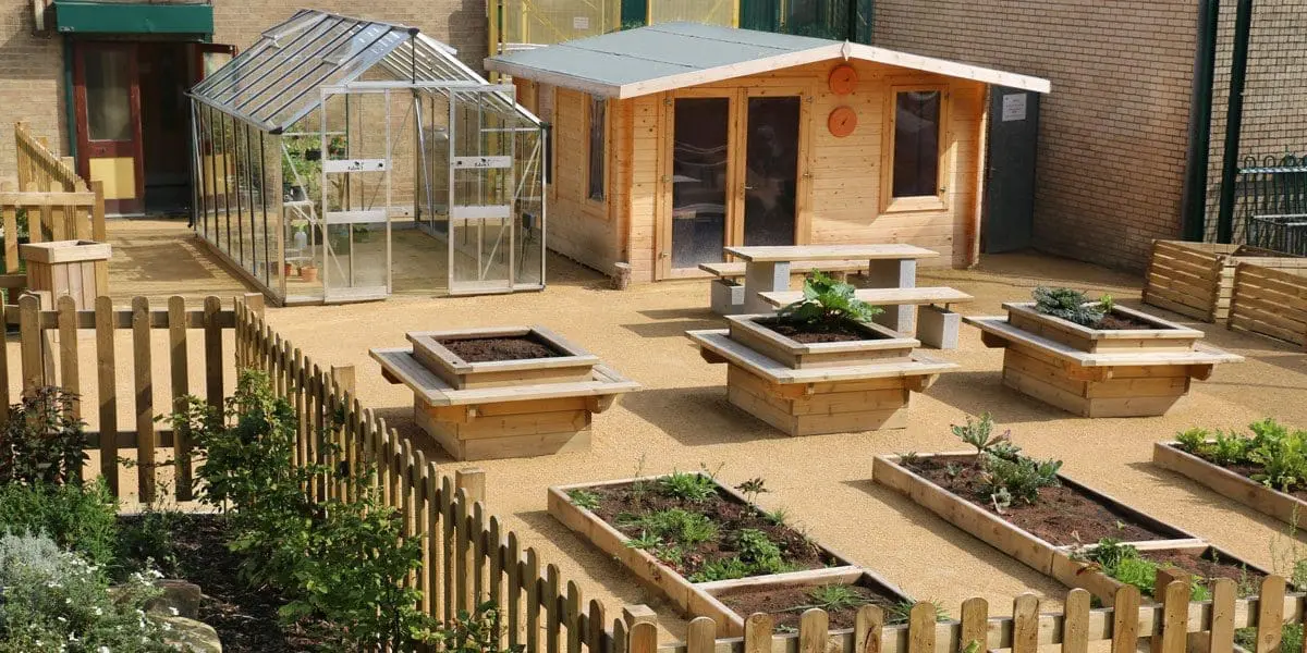 Rows of long raised plant beds and taller square planters with attached seating