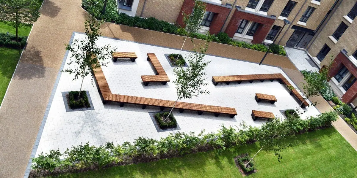 Birdseye view of university showing courtyard angular seating area of wooden benches with black metal legs
