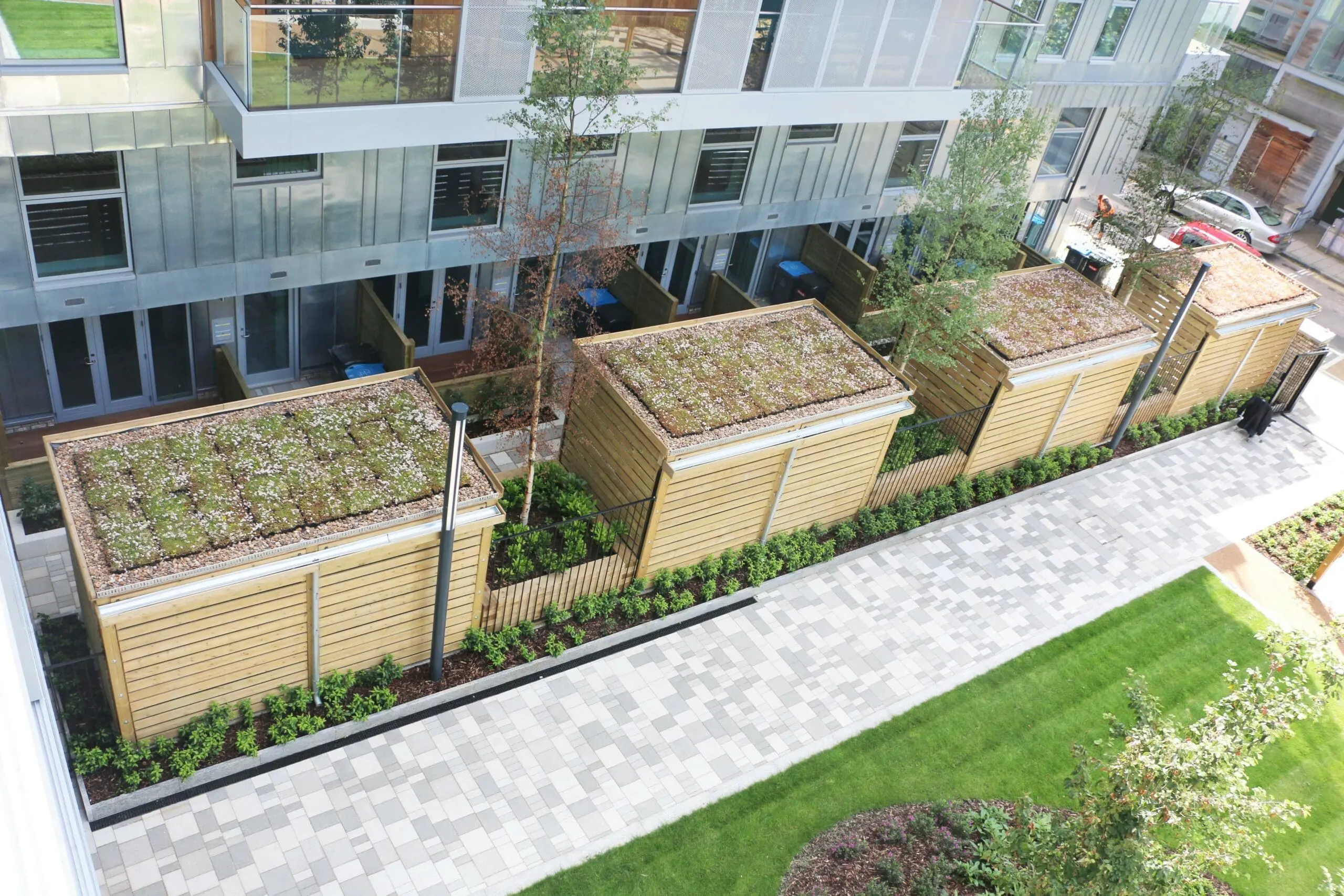 Overlooking x4 wooden huts, with gardens on the roofs. Infant trees have been planted.