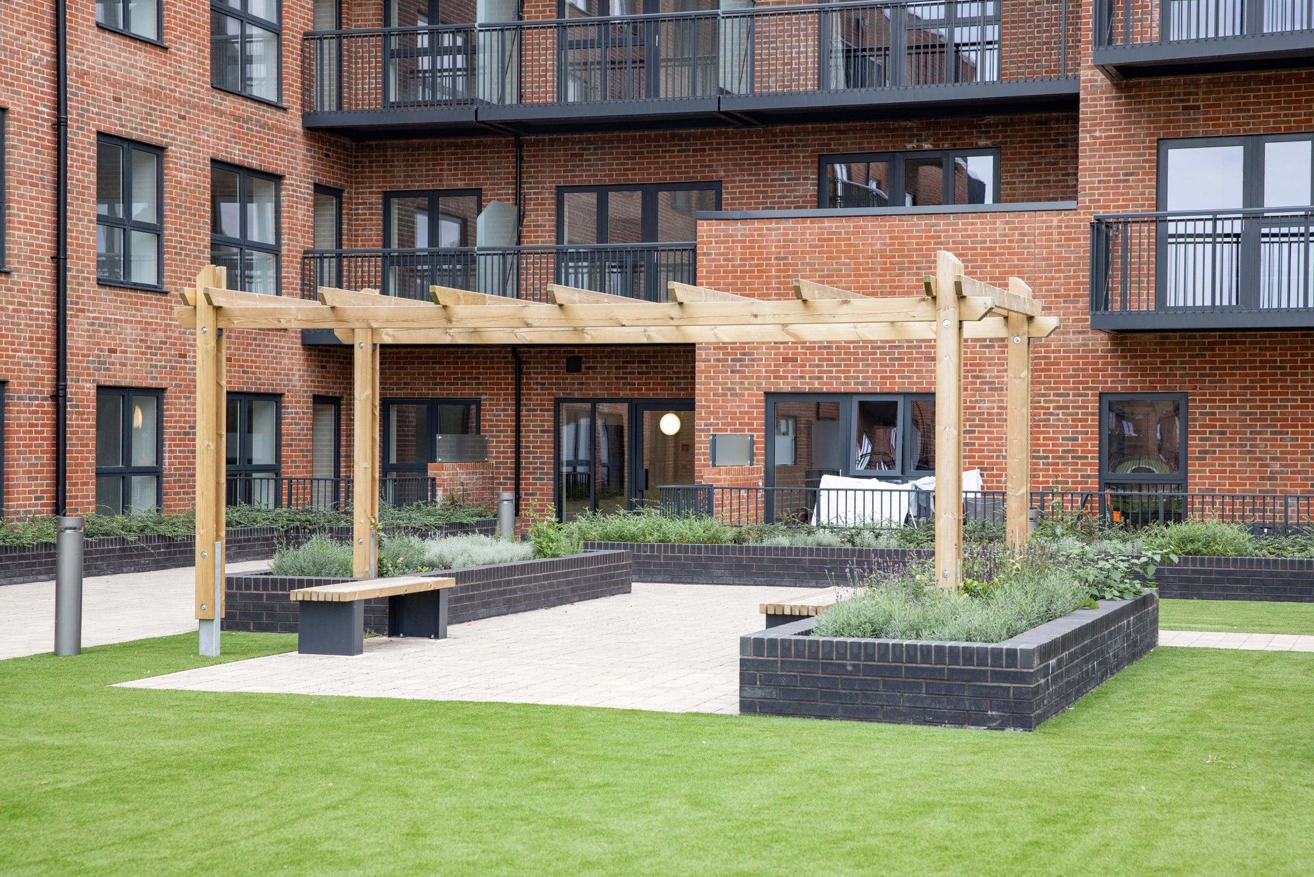housing-courtyard-with-seating-and-wooden-pergola