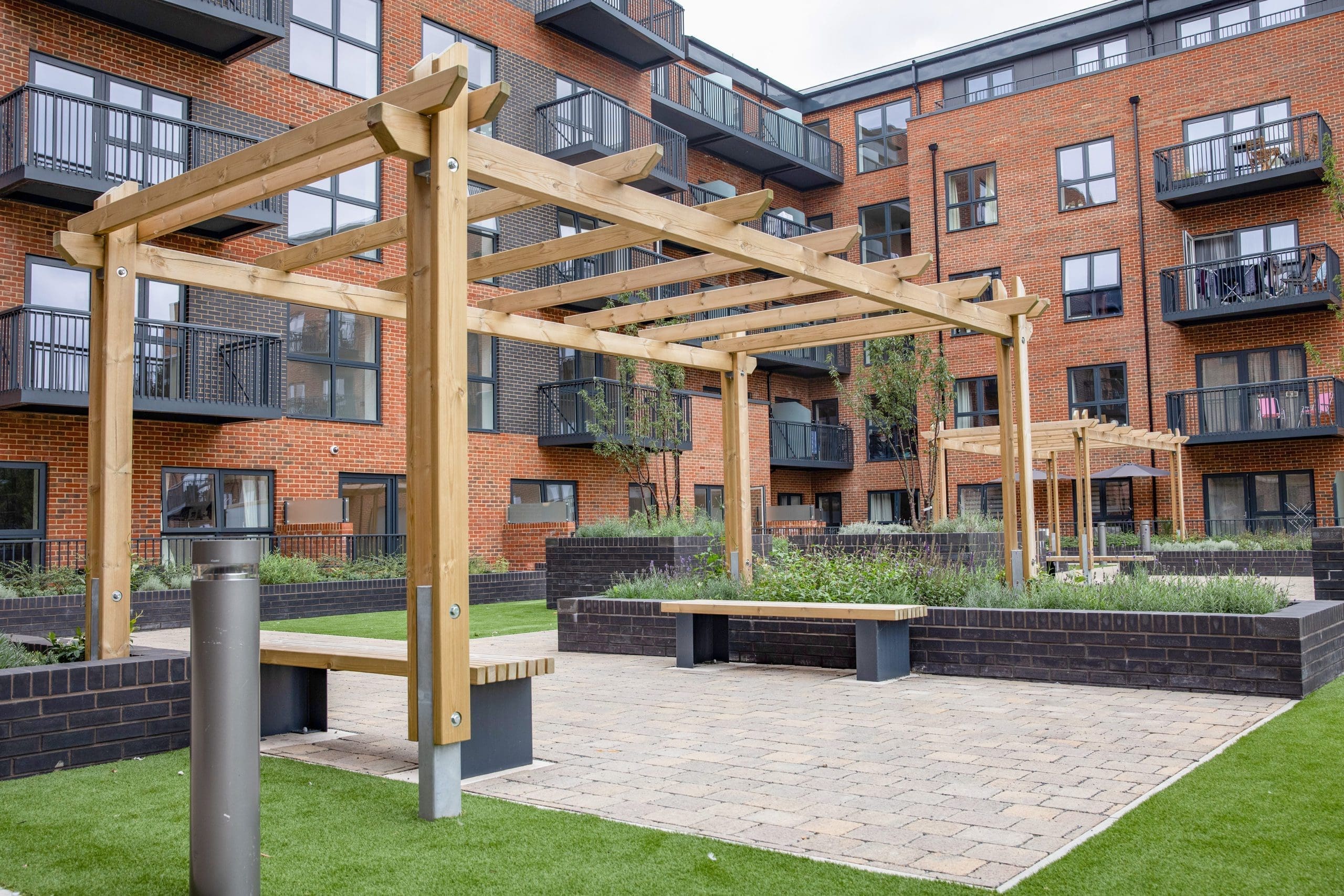 housing-courtyard-with-seating-and-wooden-pergola