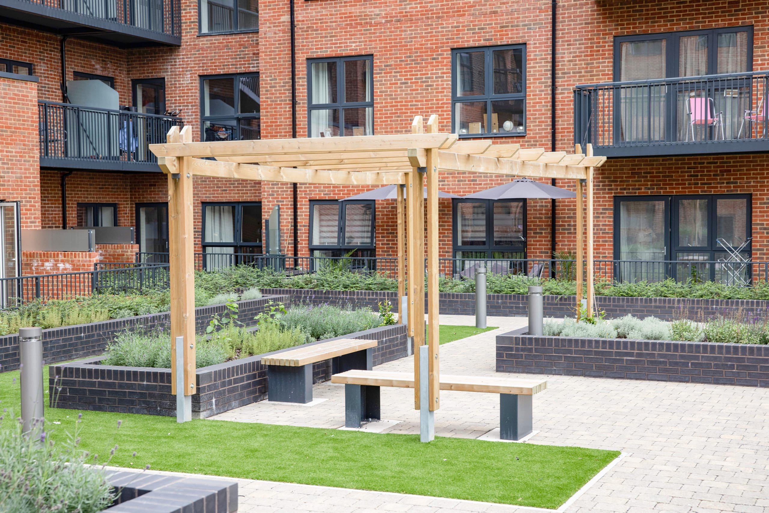 housing-courtyard-with-seating-and-wooden-pergola