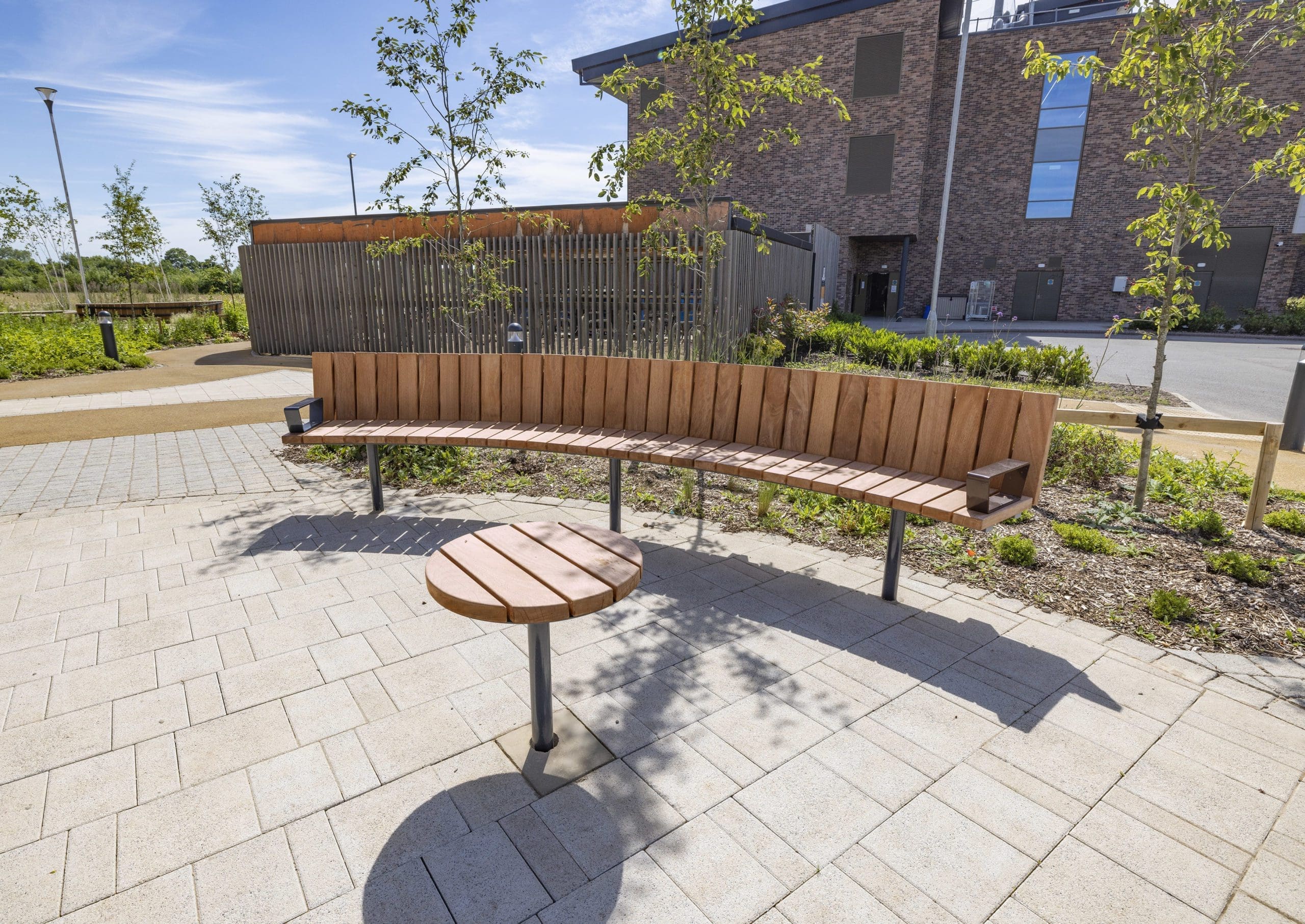 outdoor-wooden-curved-bench-metal-feet-and-small-round-matching-table