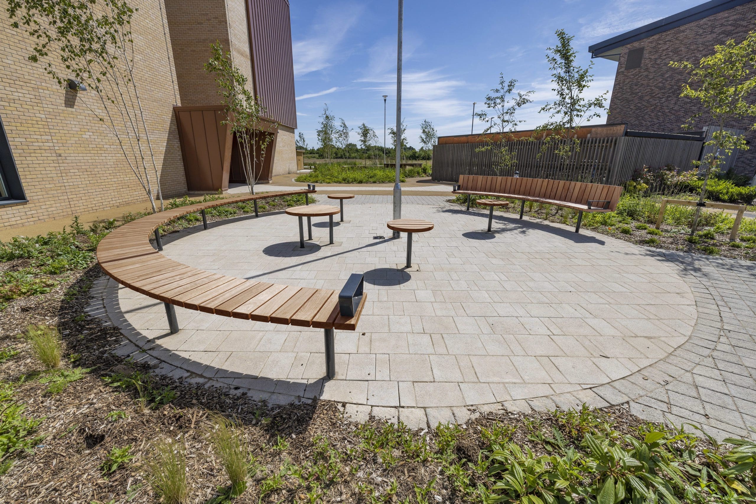 outdoor-wooden-curved-benches-metal-feet-and-small-round-matching-tables
