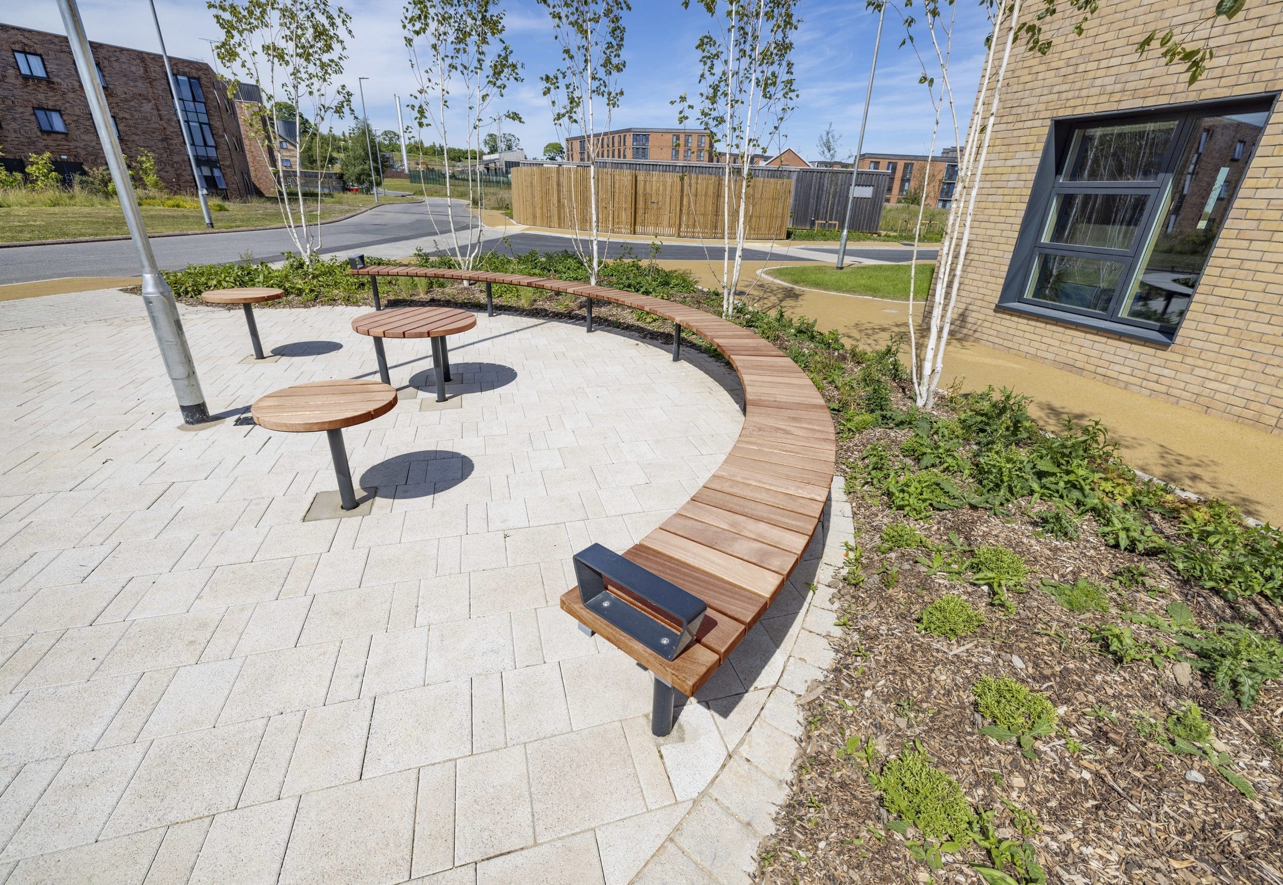 outdoor-wooden-curved-bench-metal-feet-and-small-round-matching-tables