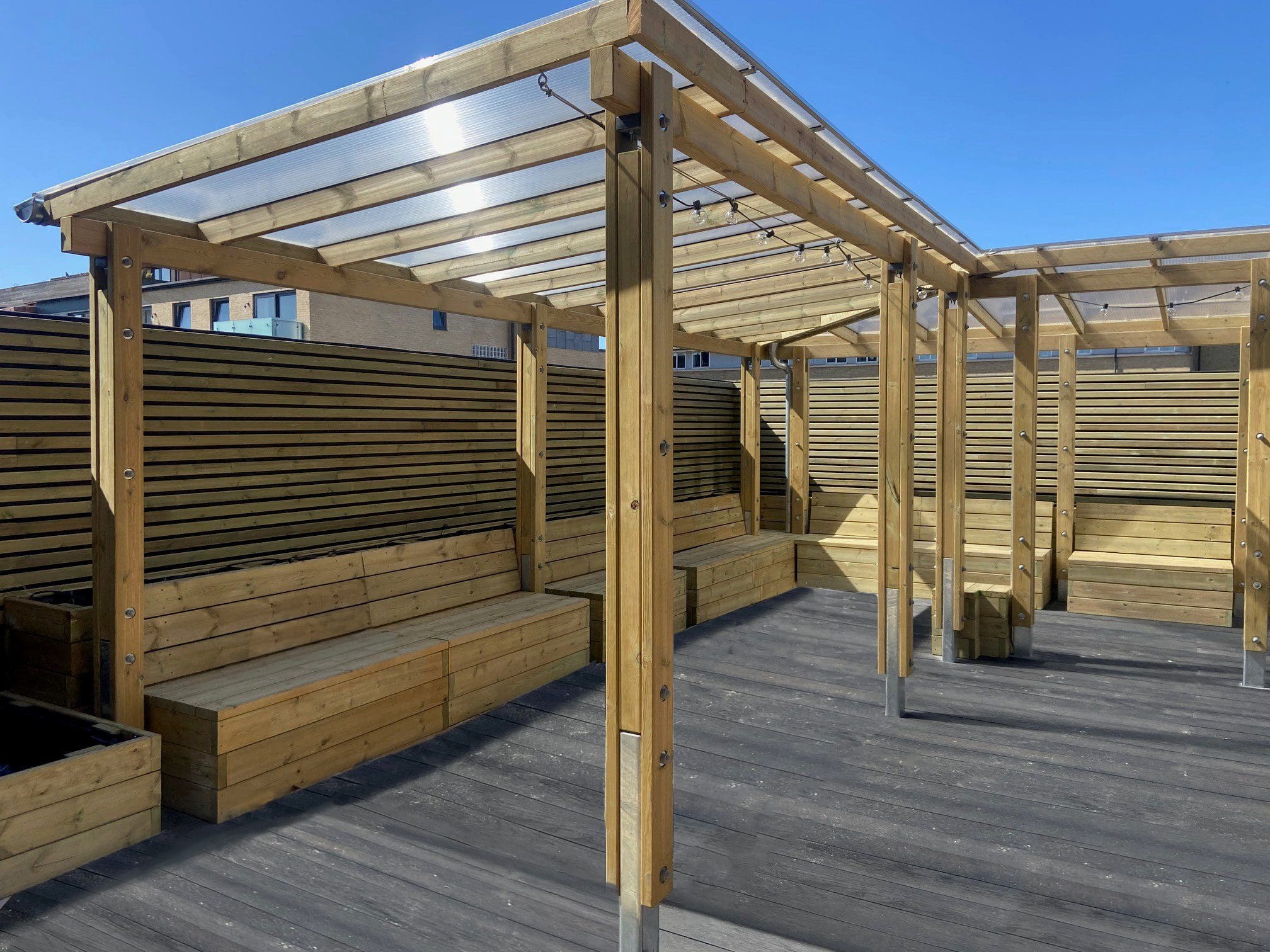 bespoke wooden pergolas with built in benches attached to raised planters