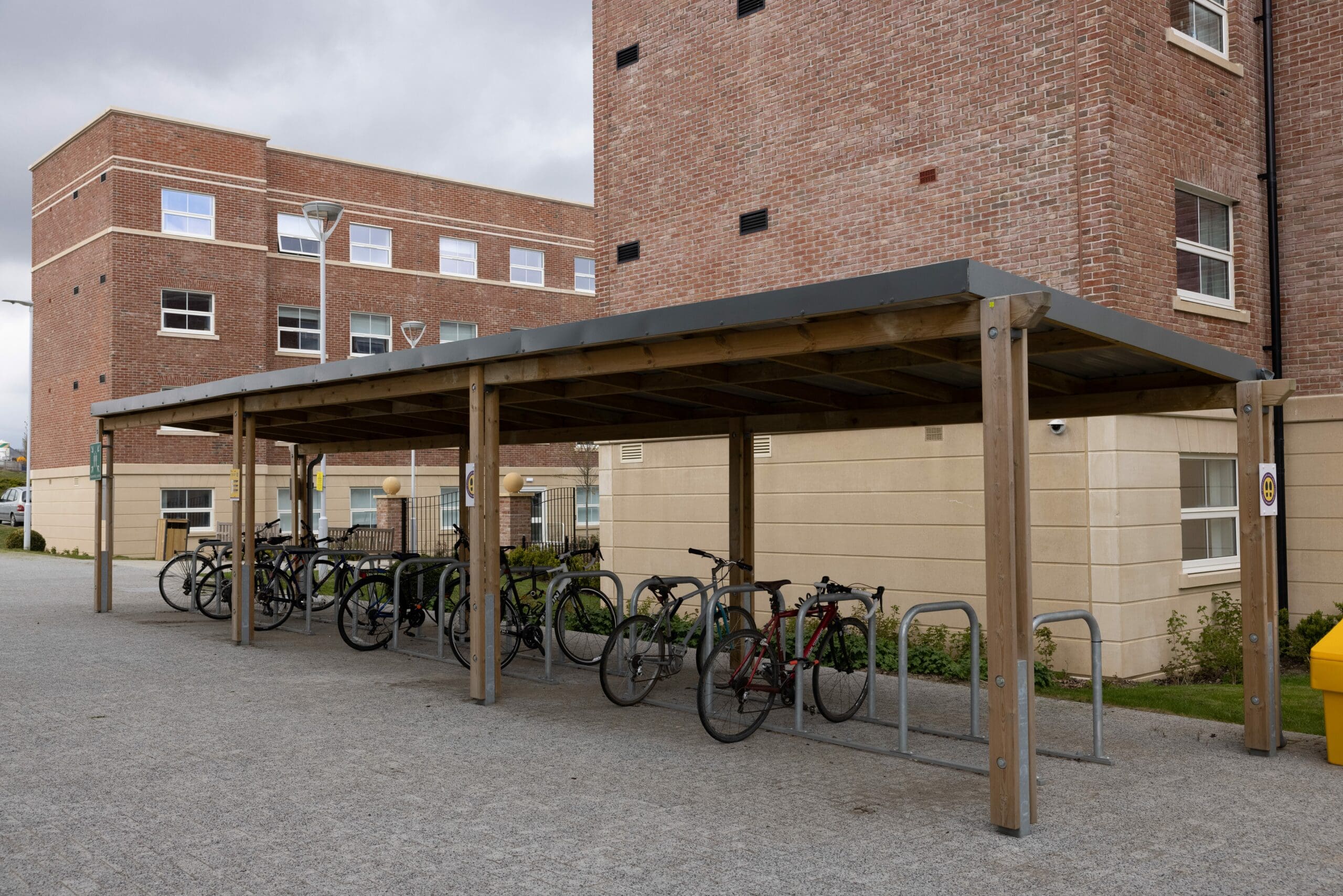 Outdoor wooden pergola canopy with bicycle security hoops underneath