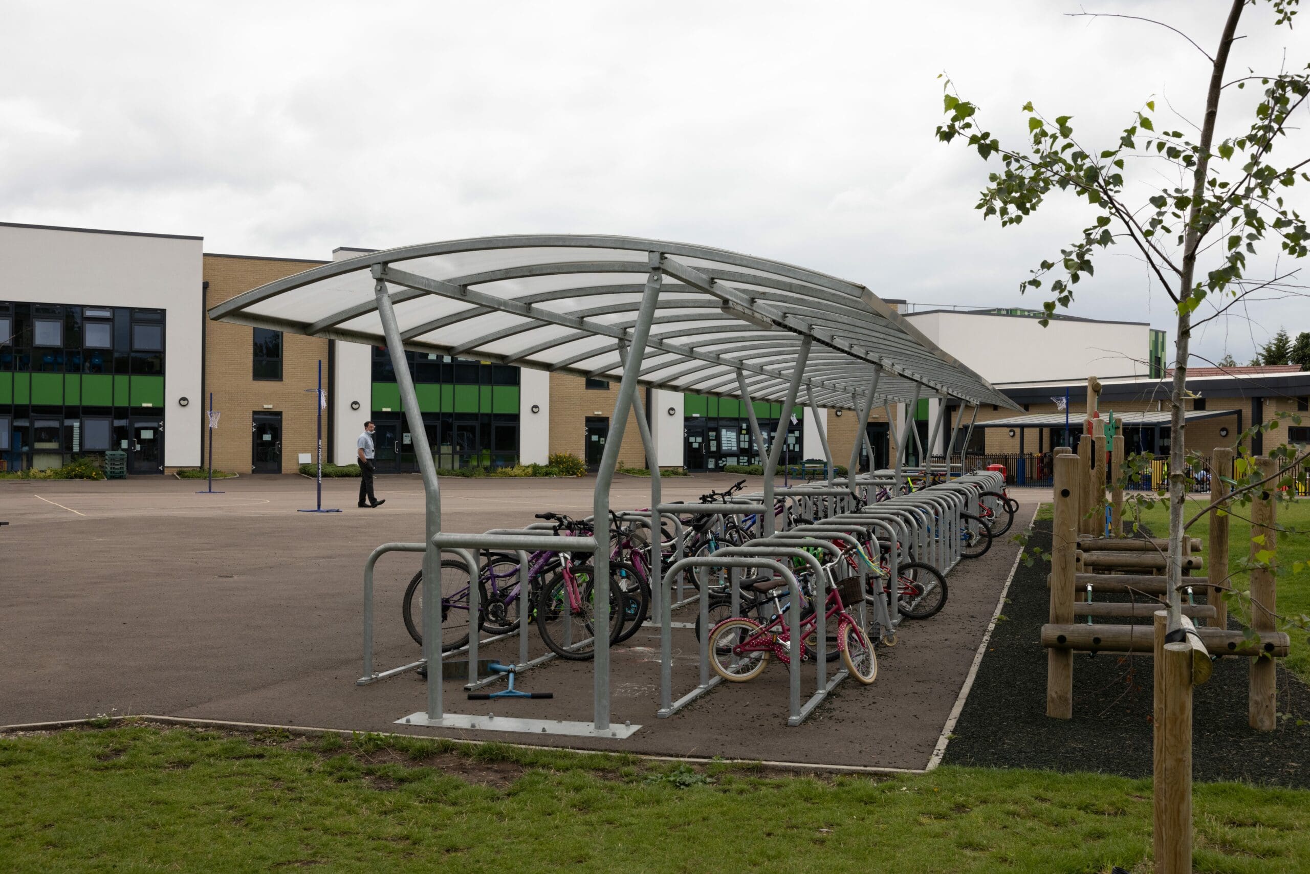 Outdoor large metal bicycle storage with canopy filled with childrens bikes