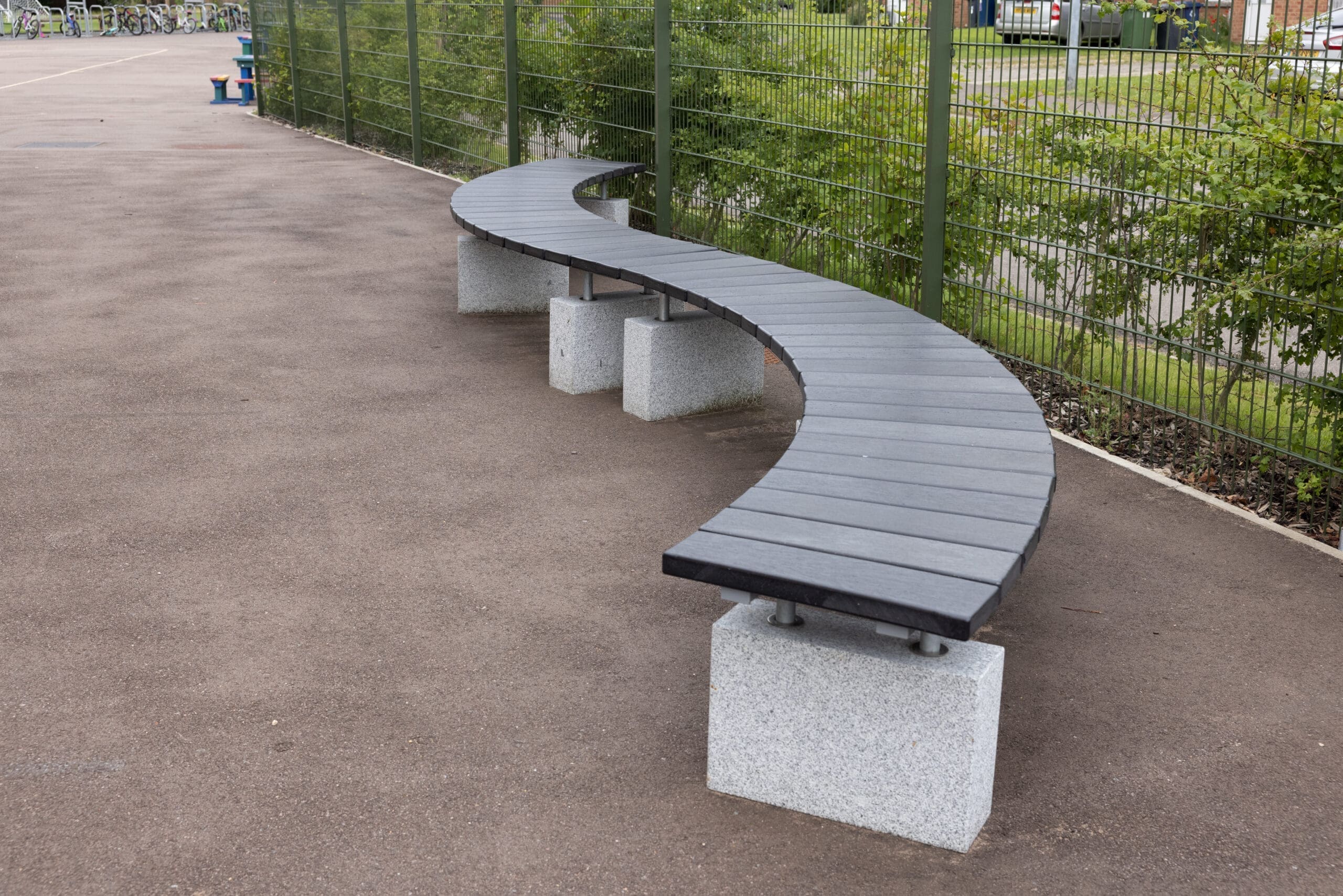 S shaped curved outdoor bench black wood concrete plinths