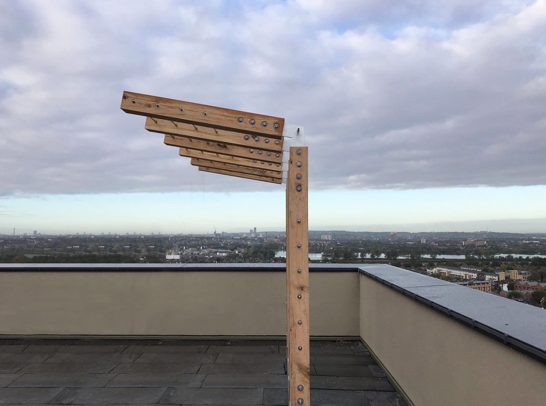 Outdoor wooden L shaped pergola with metal wired between pillars