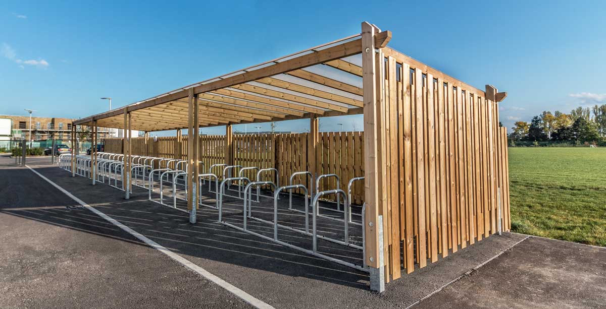 Long wooden canopy bike shelter with rows of metal bike security hoop racks