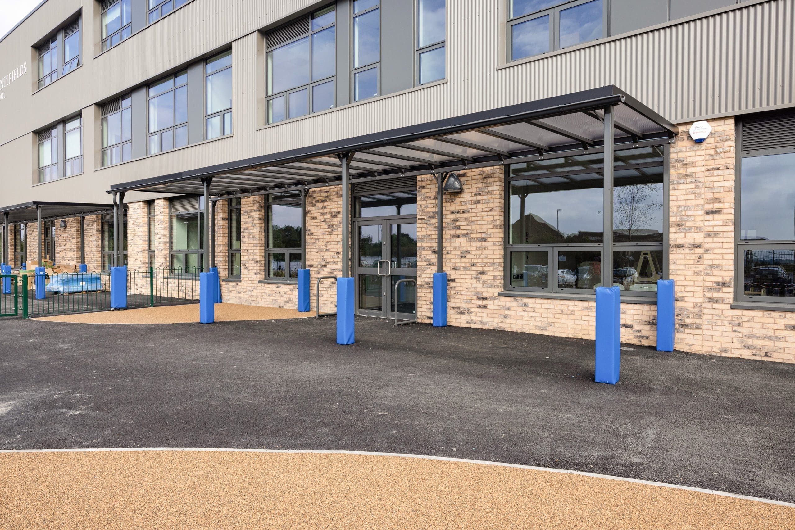 External large black metal pergola attached to side of building