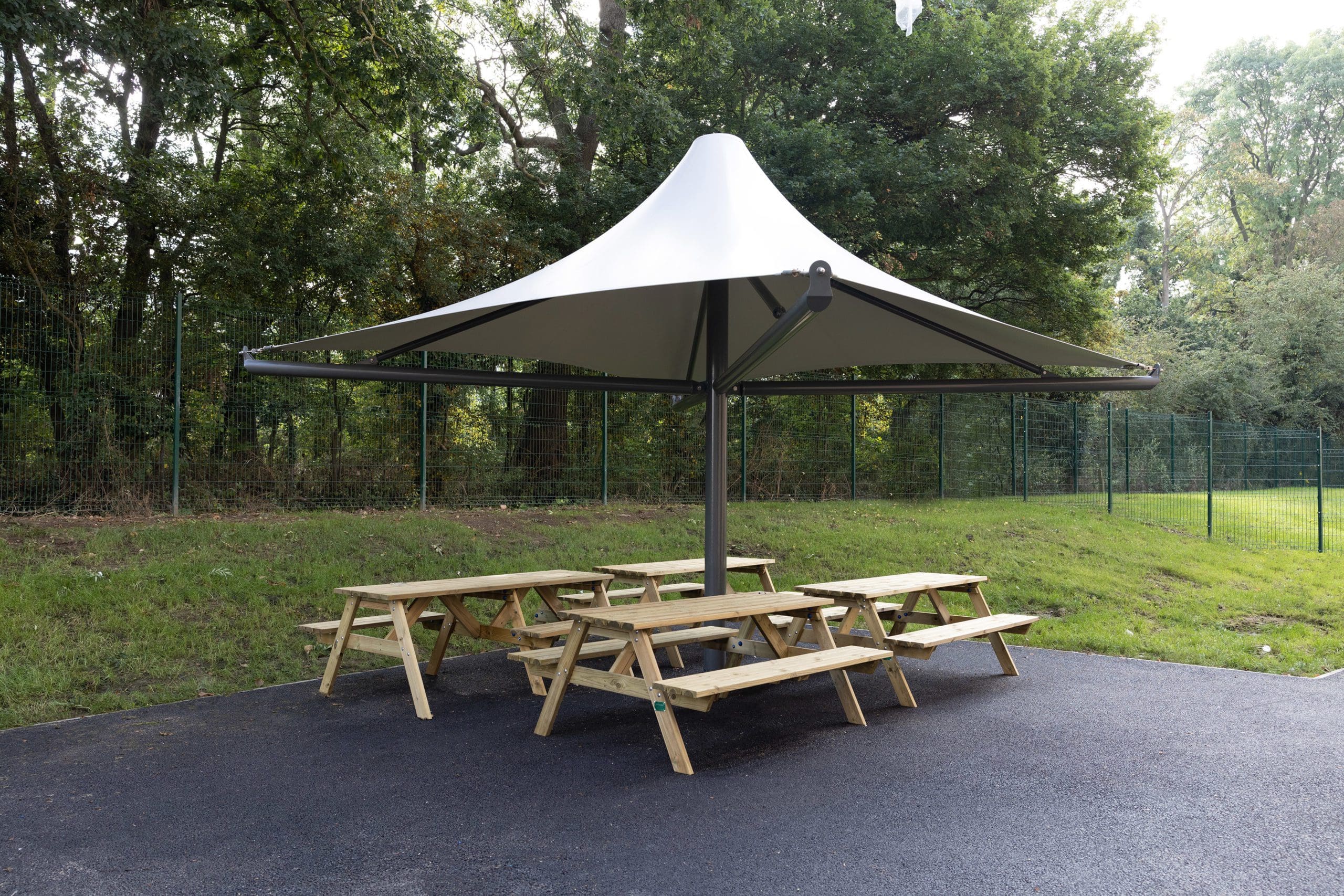 Large outdoor stretch square parasol over 4 wooden picnic tables