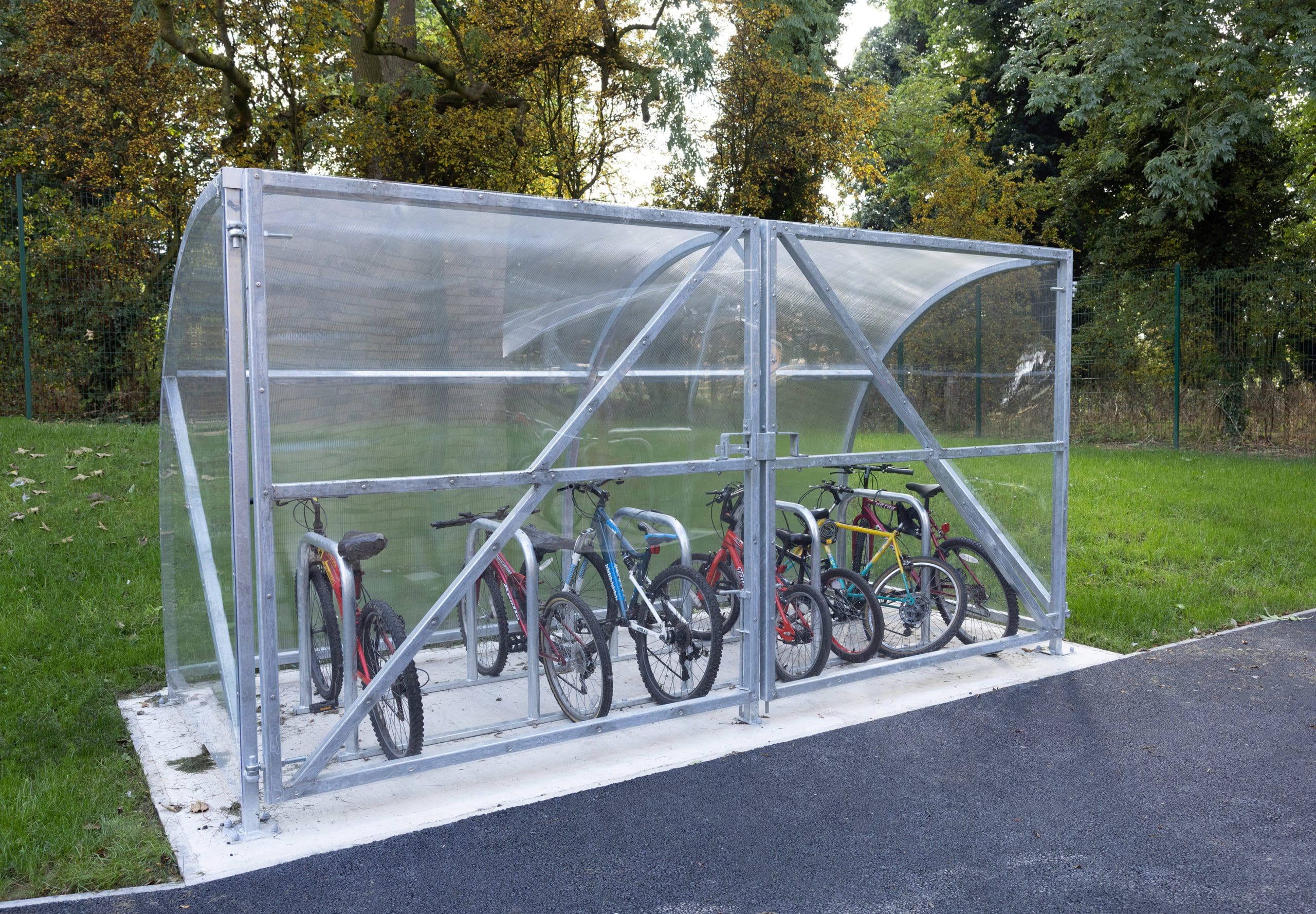 Metal outdoor bike racks with attached metal and see through canopy shelter and doors