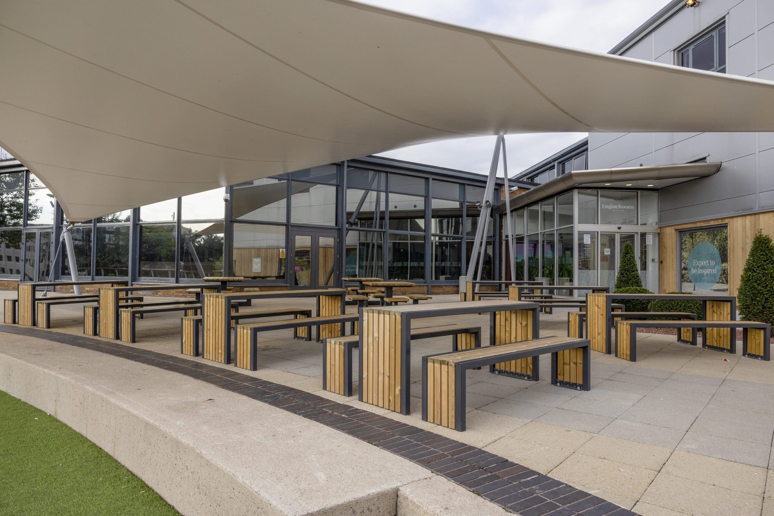 wooden-steel-framed-picnic-tables-and-chairs-under-large-stretch-canopy
