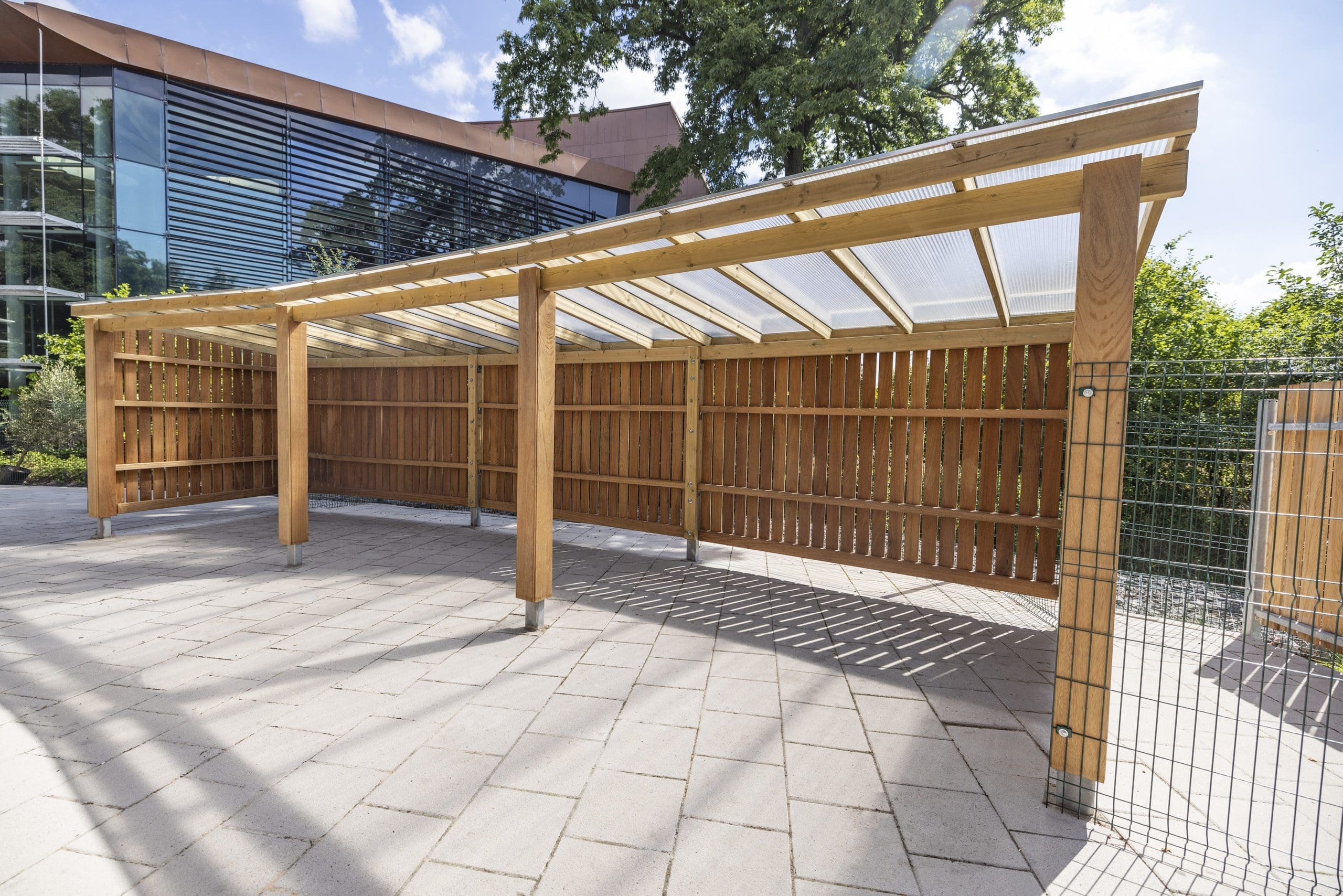 Outdoor large wooden canopy with closed sides, open front and seethrough roof
