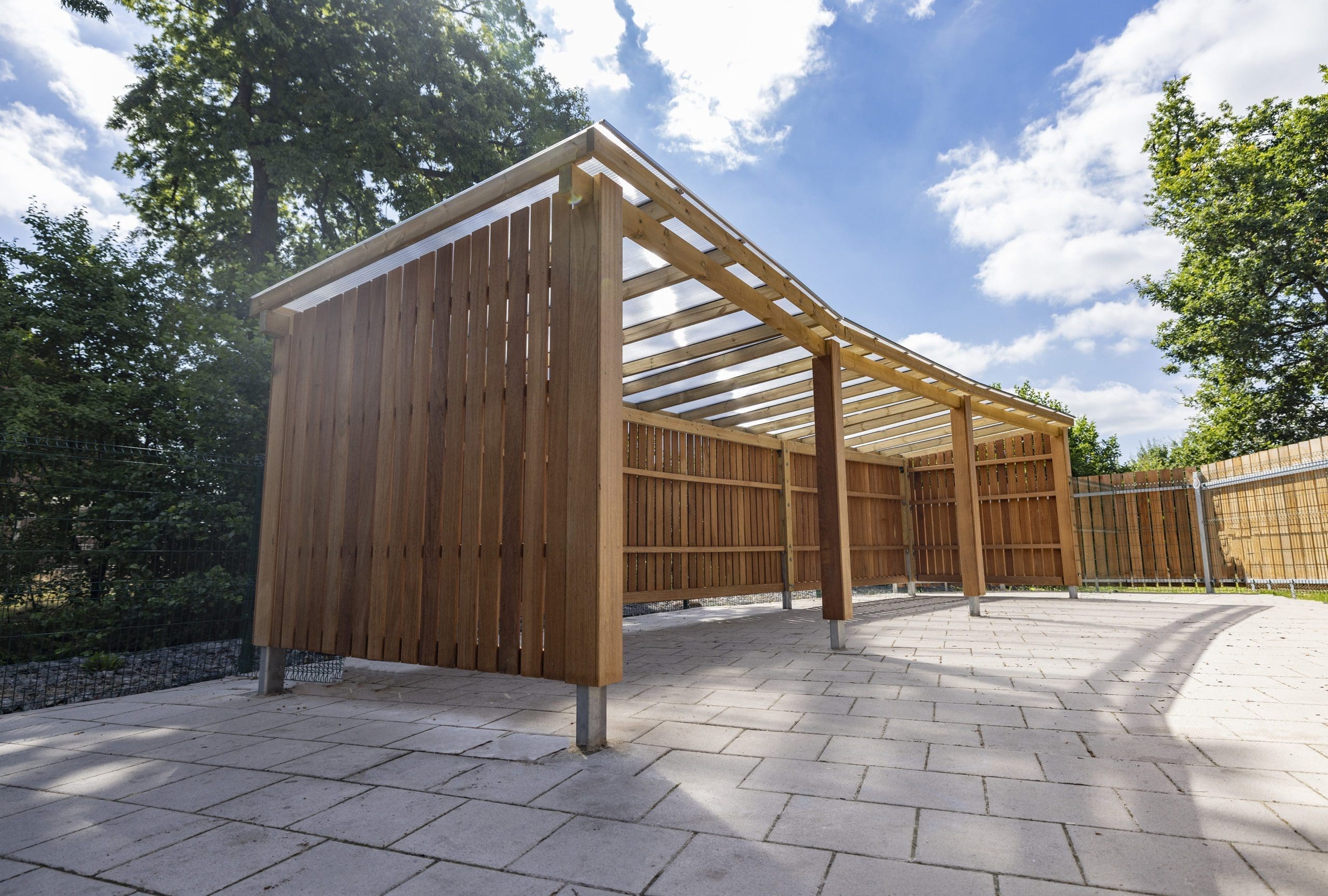 Outdoor large wooden canopy with closed sides, open front and seethrough roof