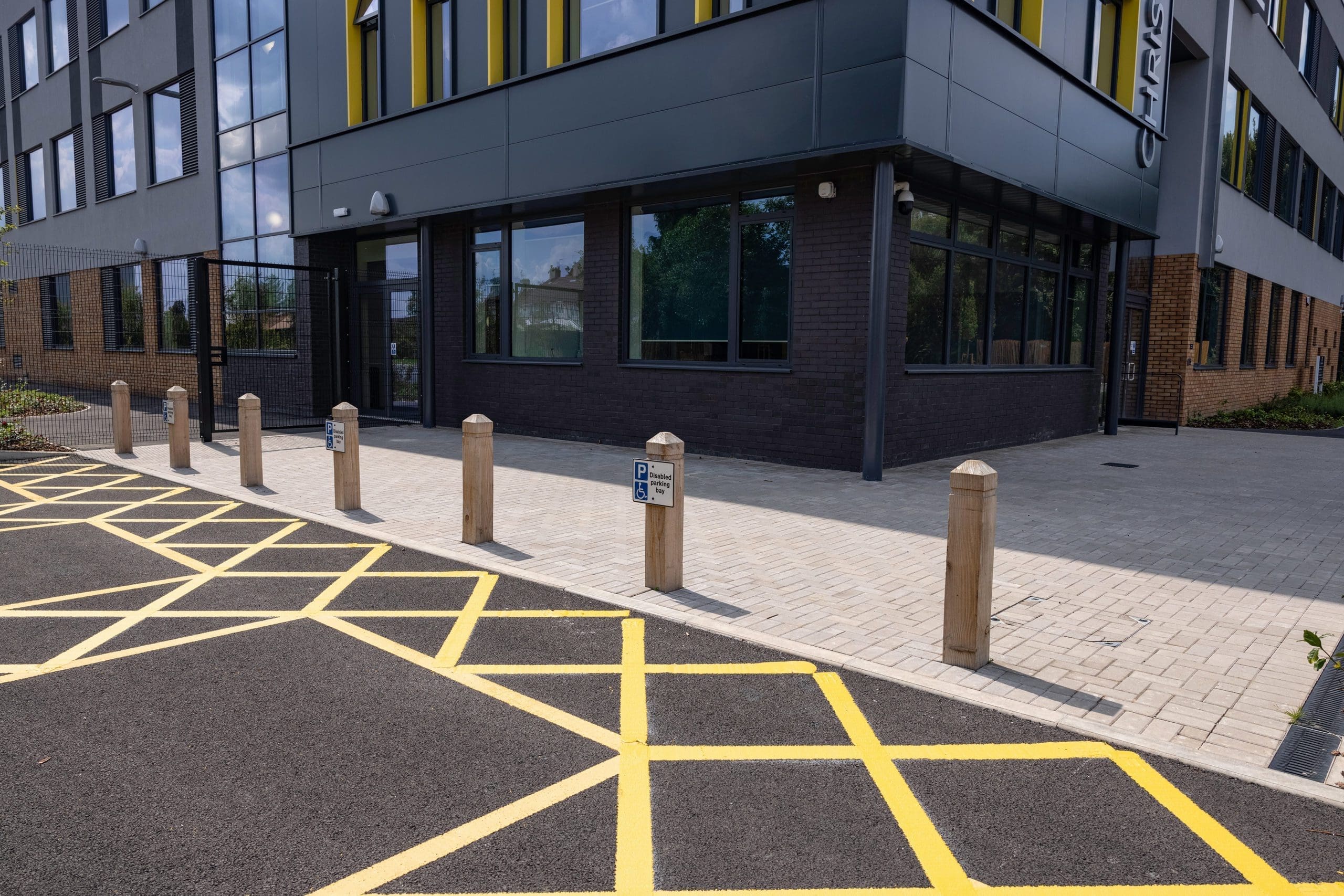 outdoor wooden parking bollards infront of school building