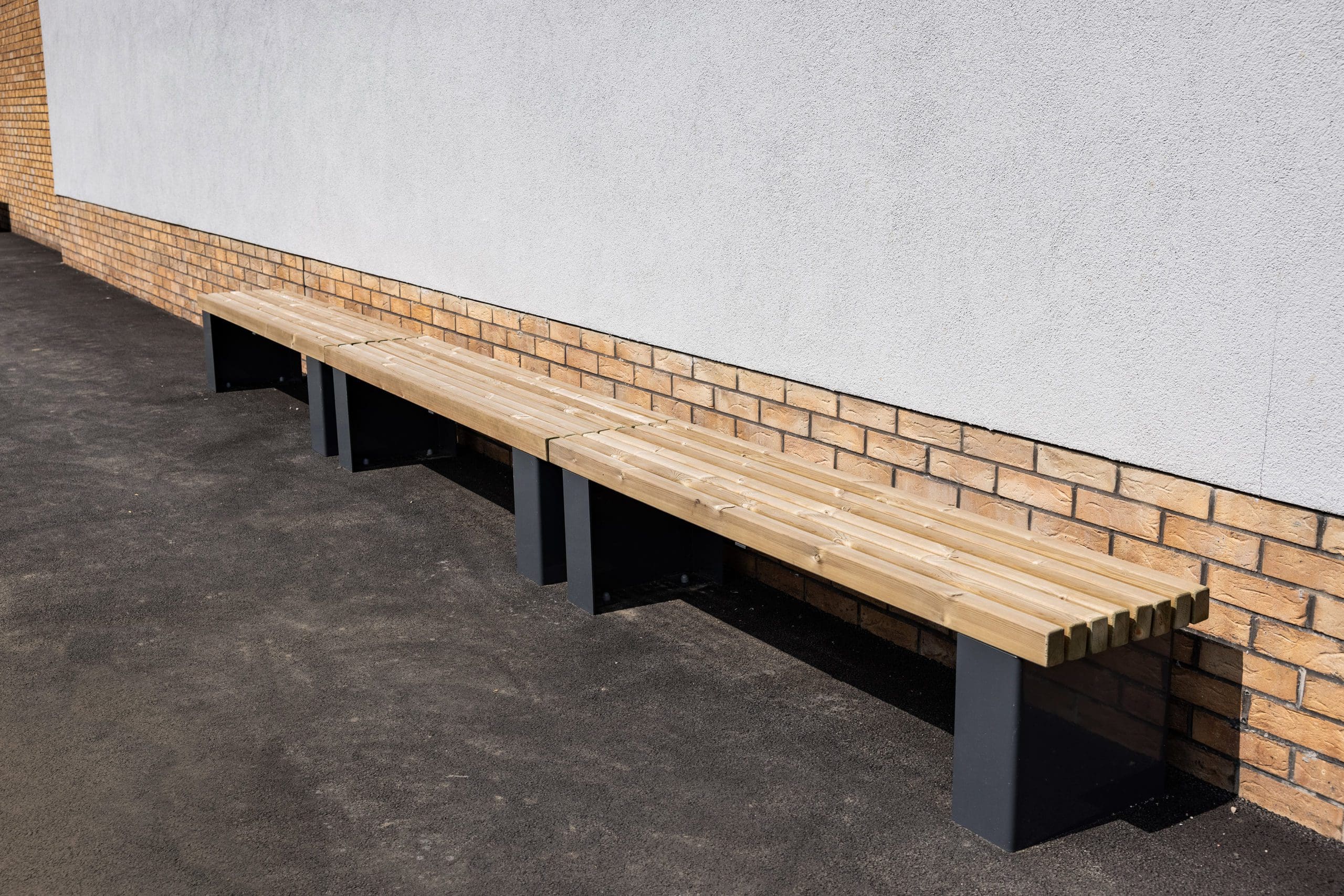 row of exterior wooden benches with dark grey metal legs