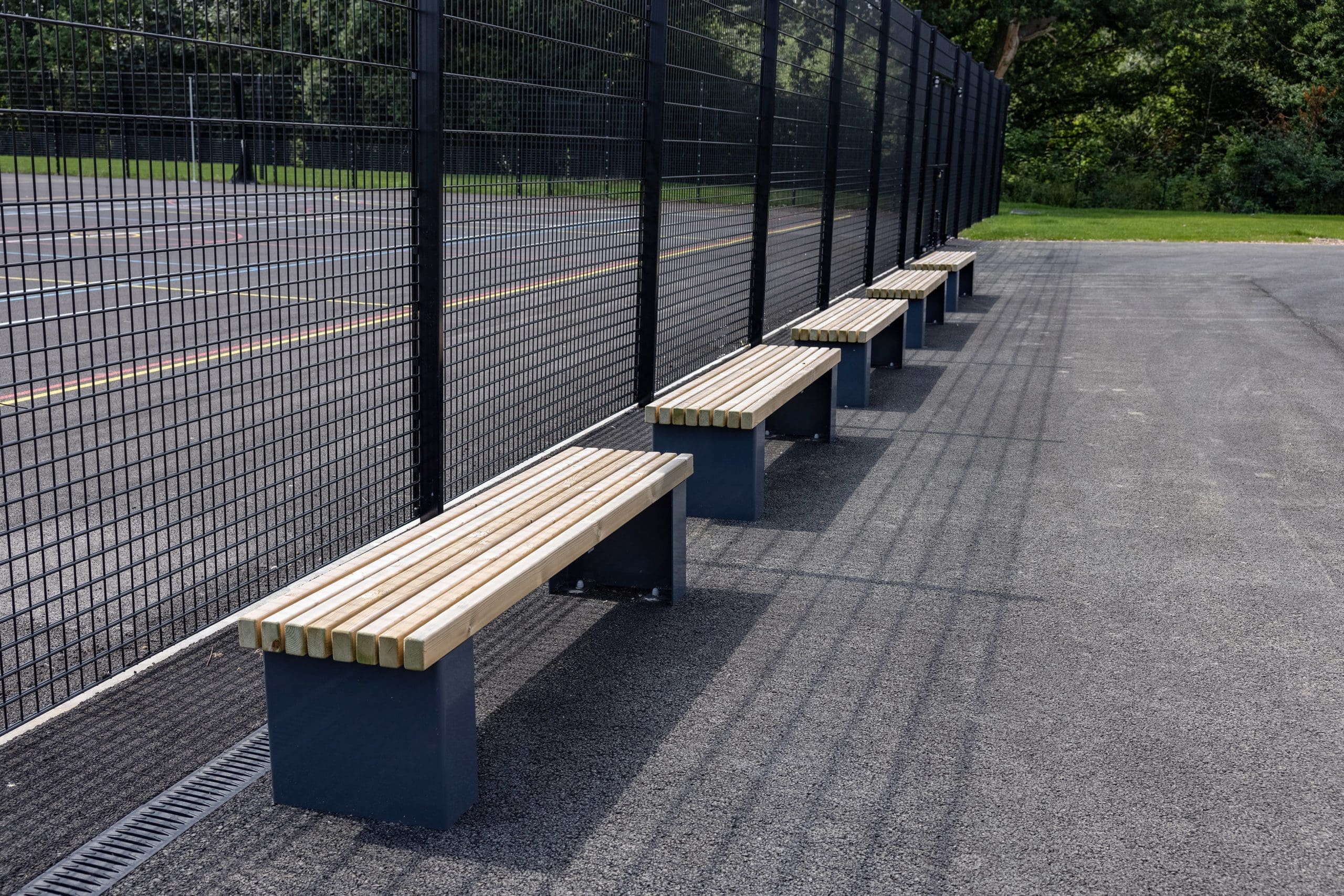 row of exterior wooden benches with dark grey metal legs