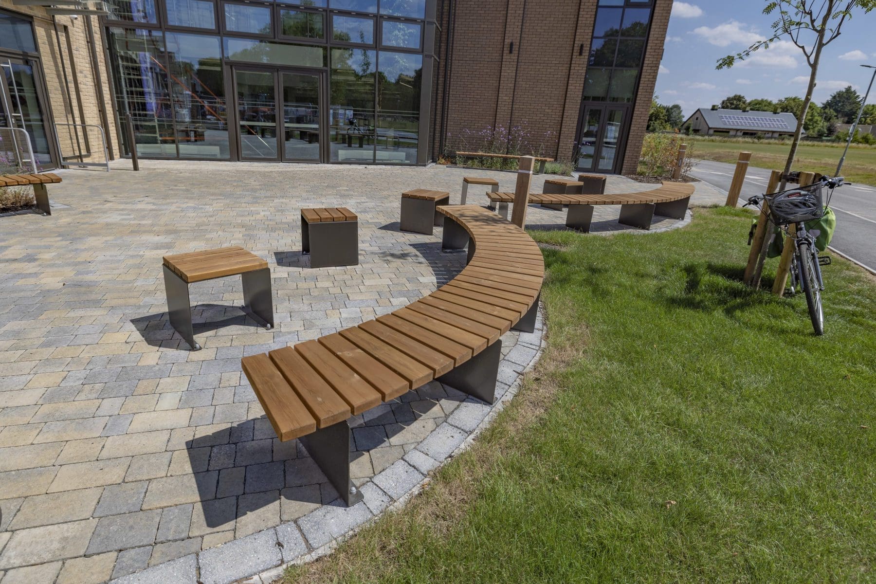 exterior-wooden-curved-benches-black-metal-legs-and-matching-single-seats