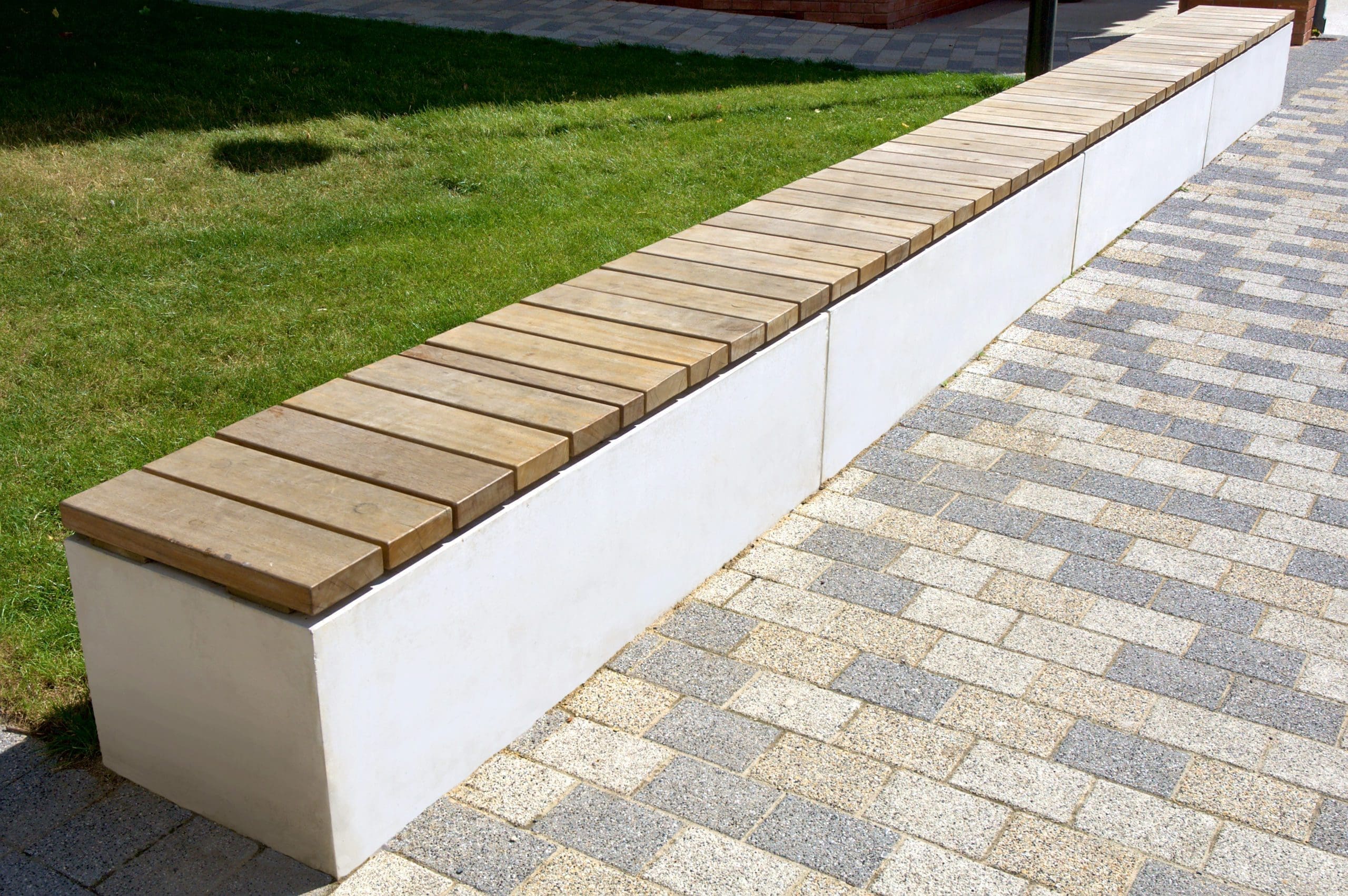 Long line of concrete rectangle benches with wooden slats on top