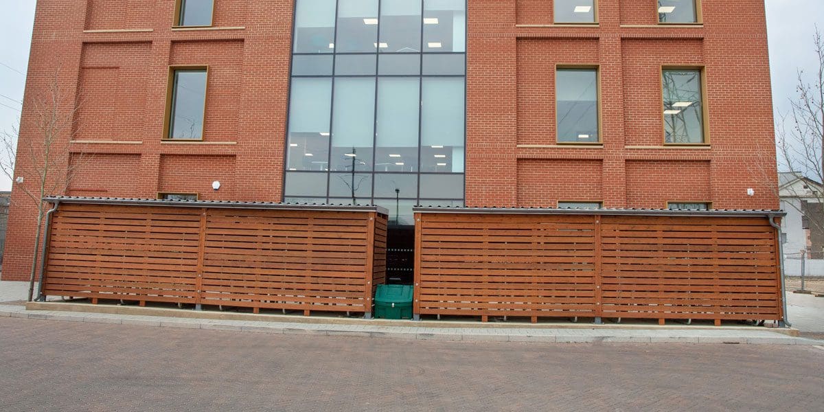 External wooden cycle storage units infront of office building