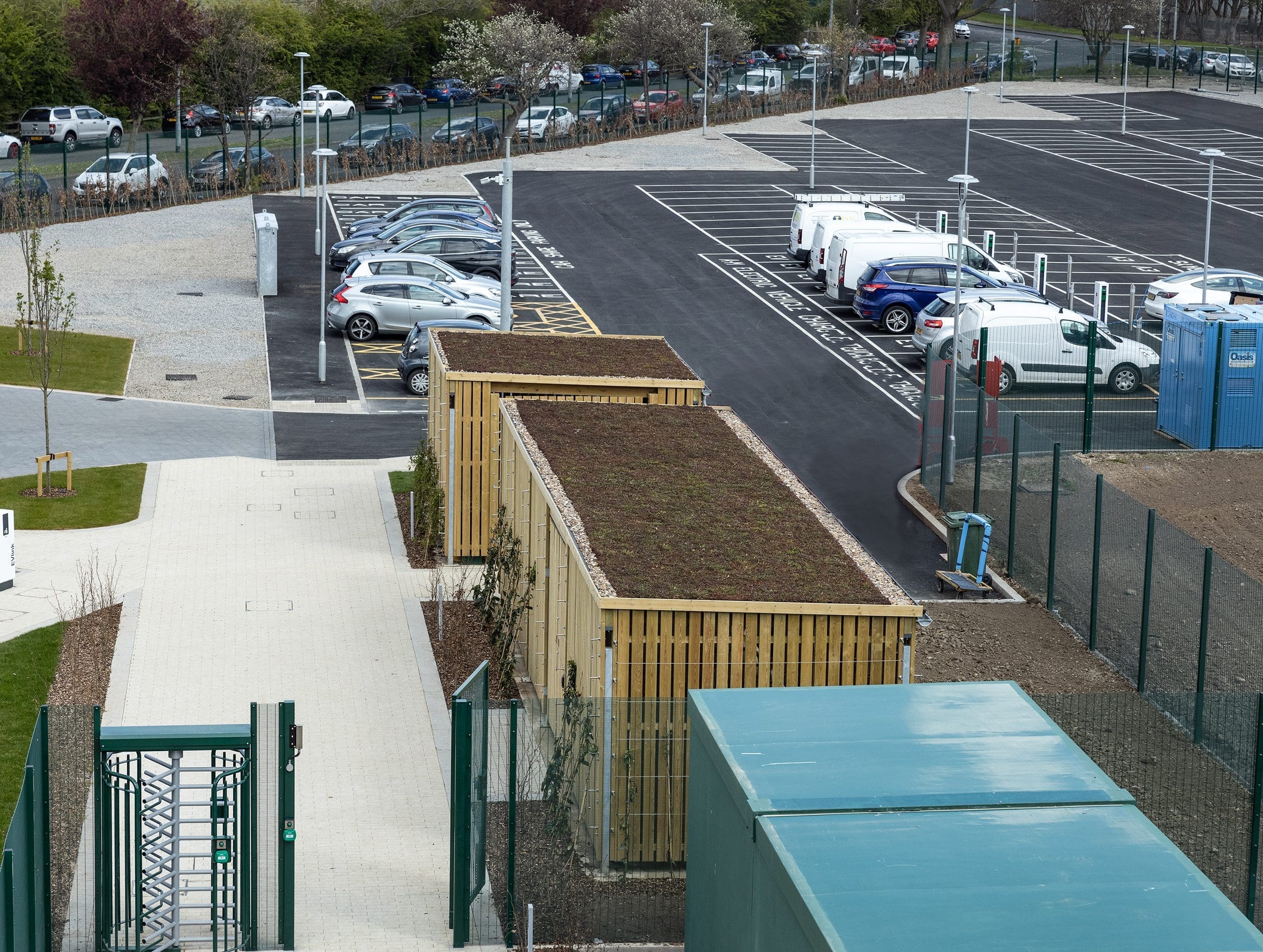 Wide shot of outdoor large wooden cycle storage unit and bin storage unit with living roofs