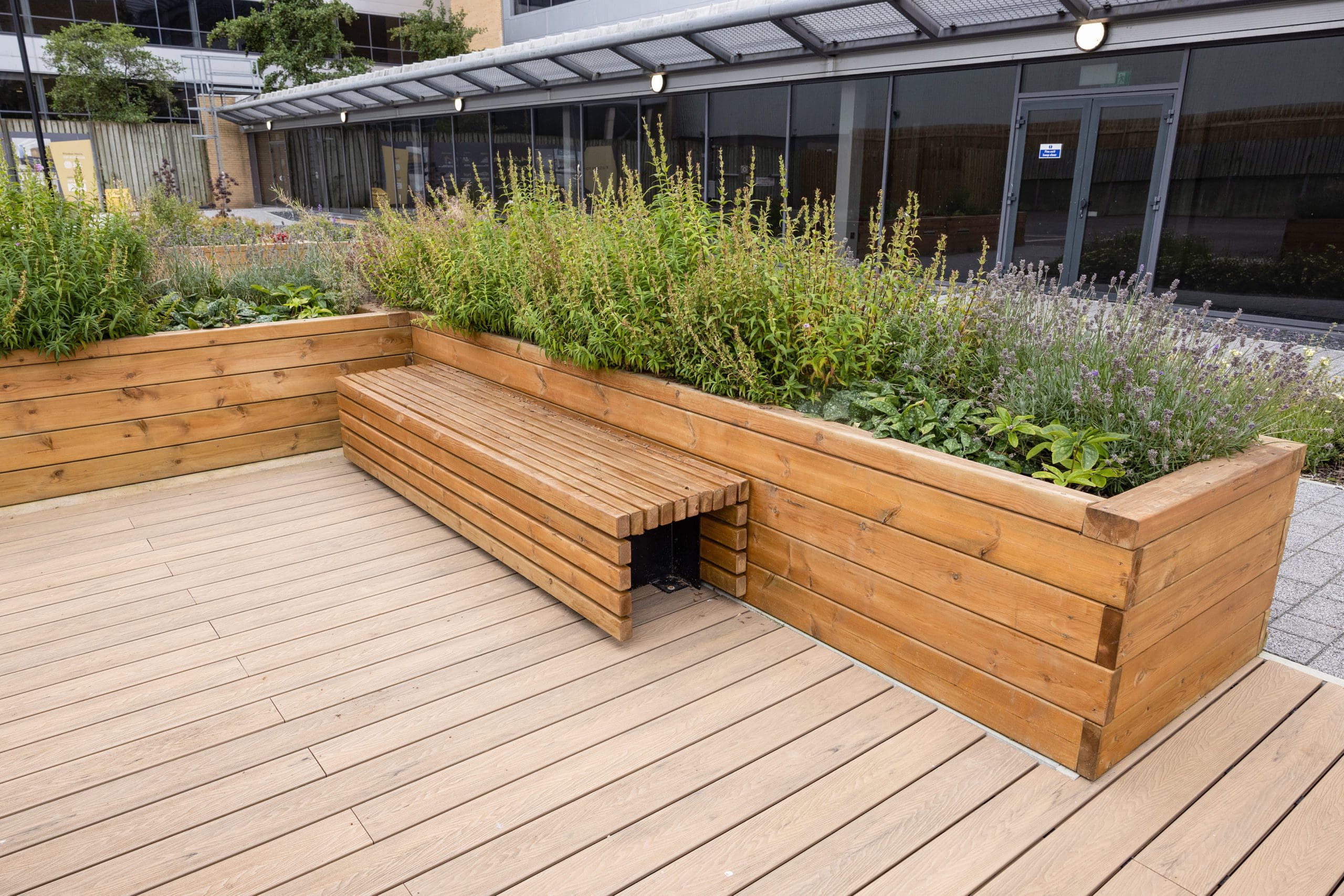 l-shaped-wooden-raised-planters-with-wooden-bench-infront