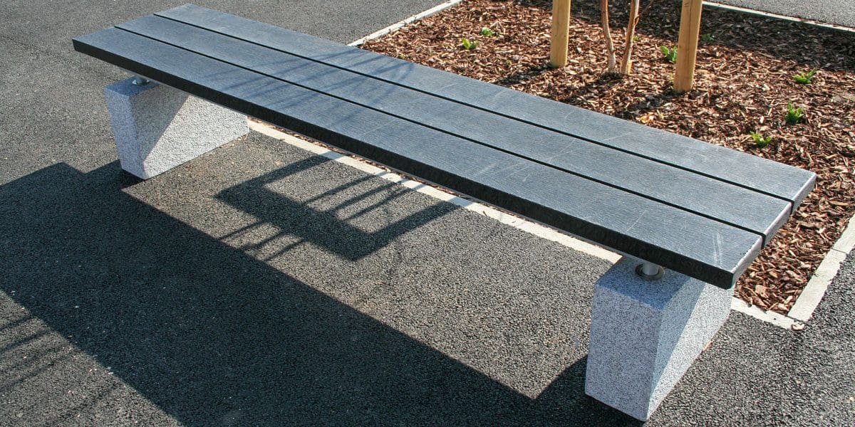 Outdoor black wooden bench with concrete plinth legs