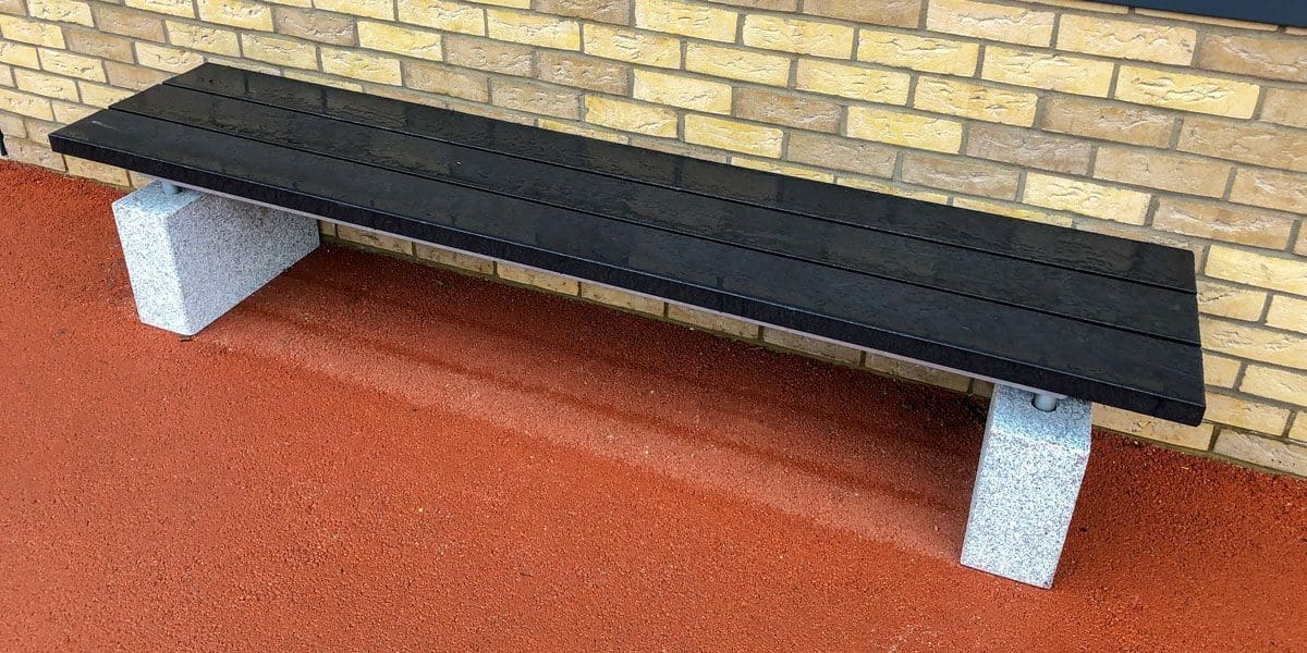 Outdoor black wooden bench with concrete plinth legs