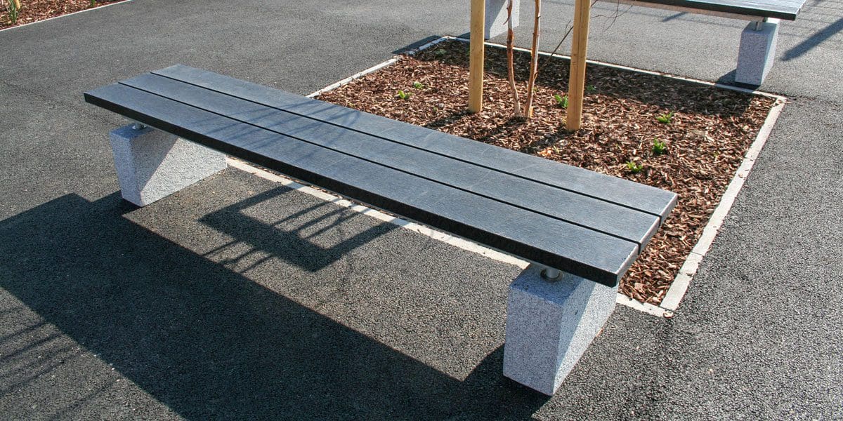 Outdoor black wooden bench with concrete plinth legs