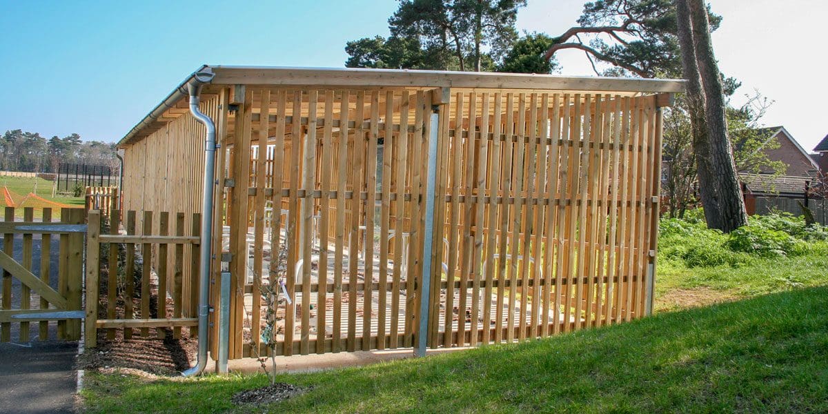 Exterior wooden bicycle shelter with inside storage and outside metal bike hoops