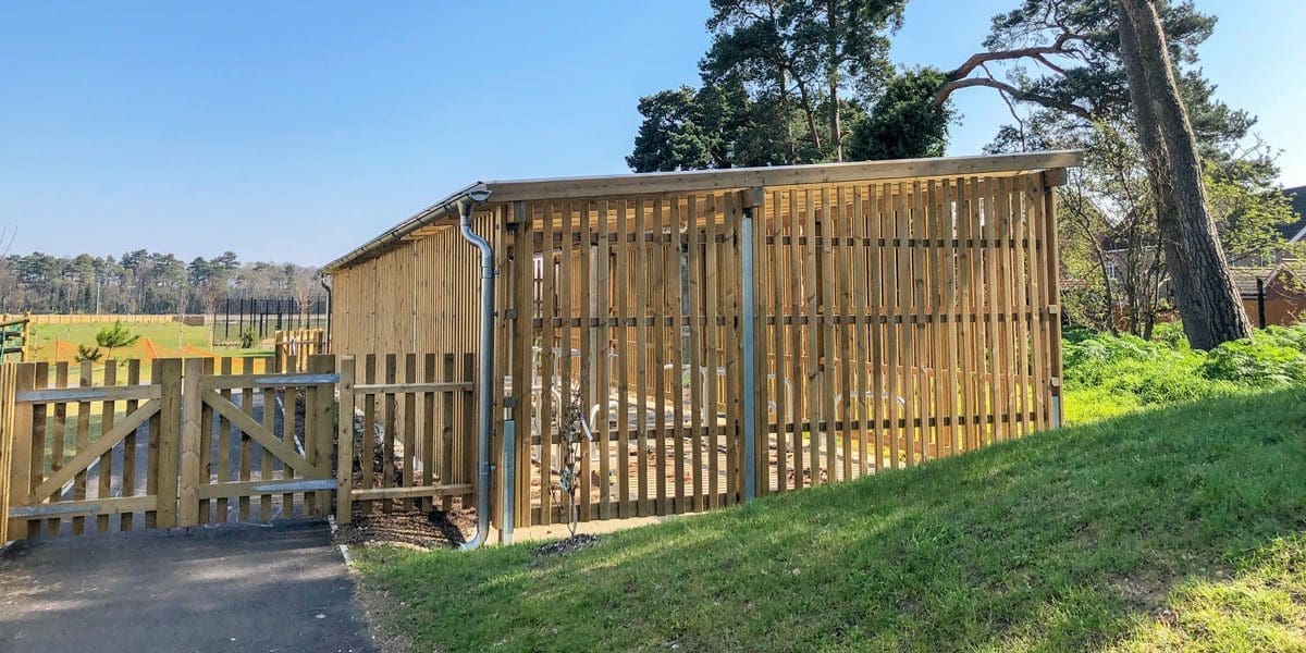 Exterior wooden bicycle shelter with inside storage and outside metal bike hoops