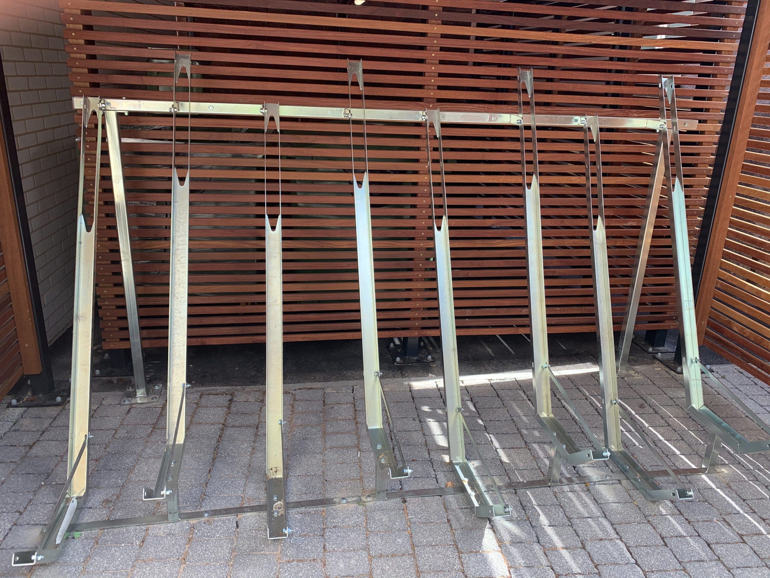 Metal bicycle storage rack for multiple bikes under wooden bike storage canopy