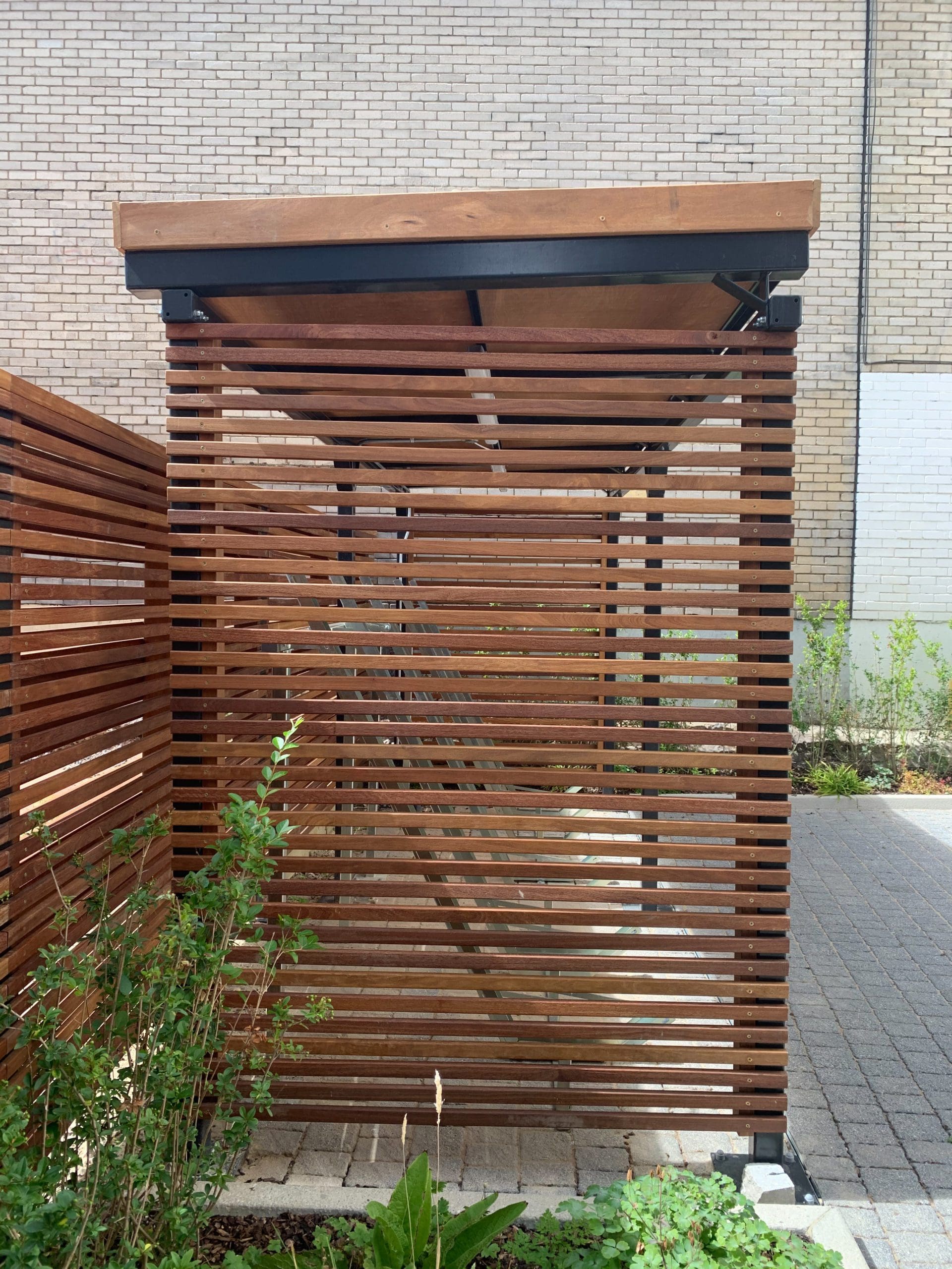 Side shot of wooden bike storage canopy and matching wooden fence