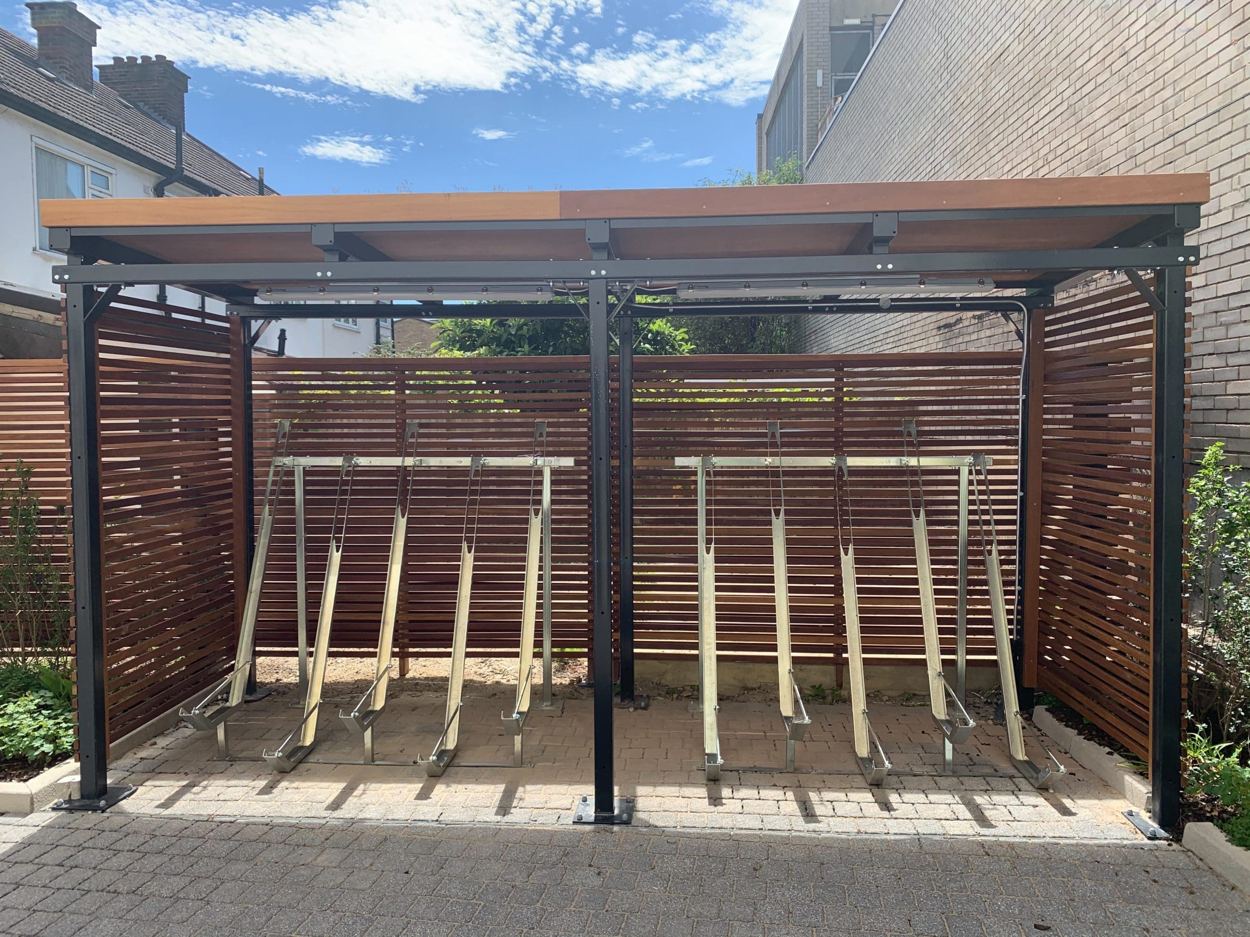 Metal bicycle storage rack for multiple bikes under wooden bike storage canopy