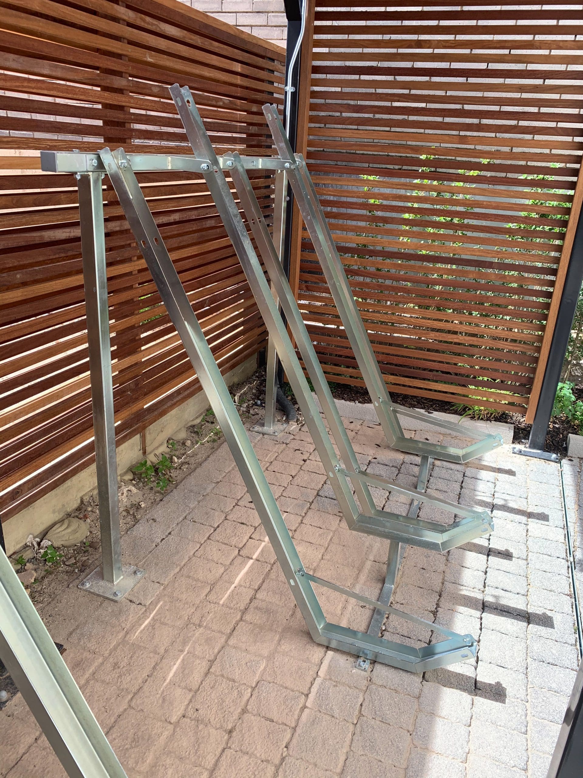 Metal bicycle storage rack for multiple bikes under wooden bike storage canopy