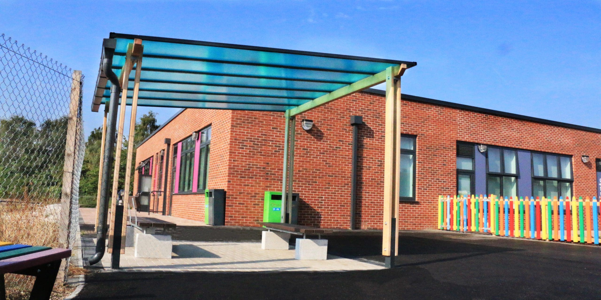 External pergola with blue tinted canopy colour infront of primary school