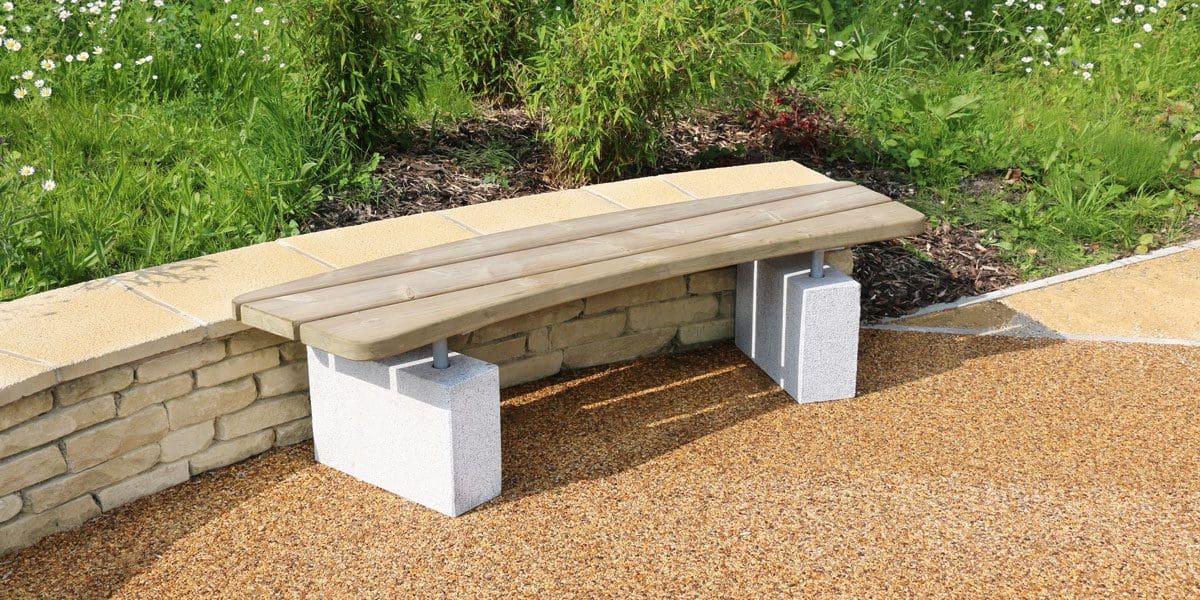 Curved wooden bench with concrete plinth legs
