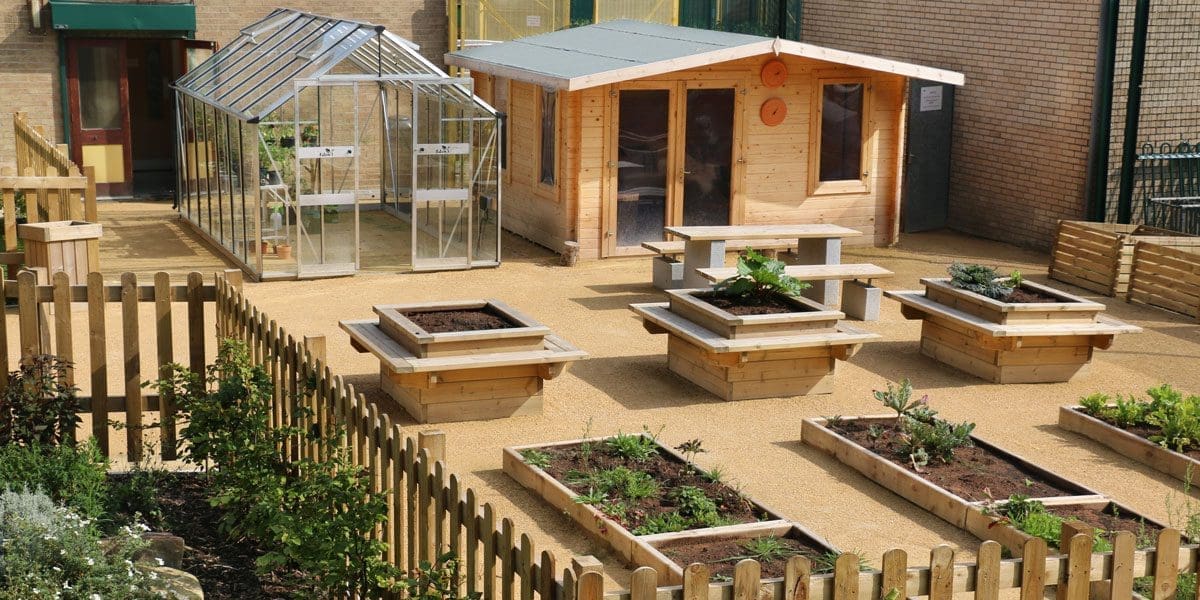 Rows of long raised plant beds and taller square planters with attached seating