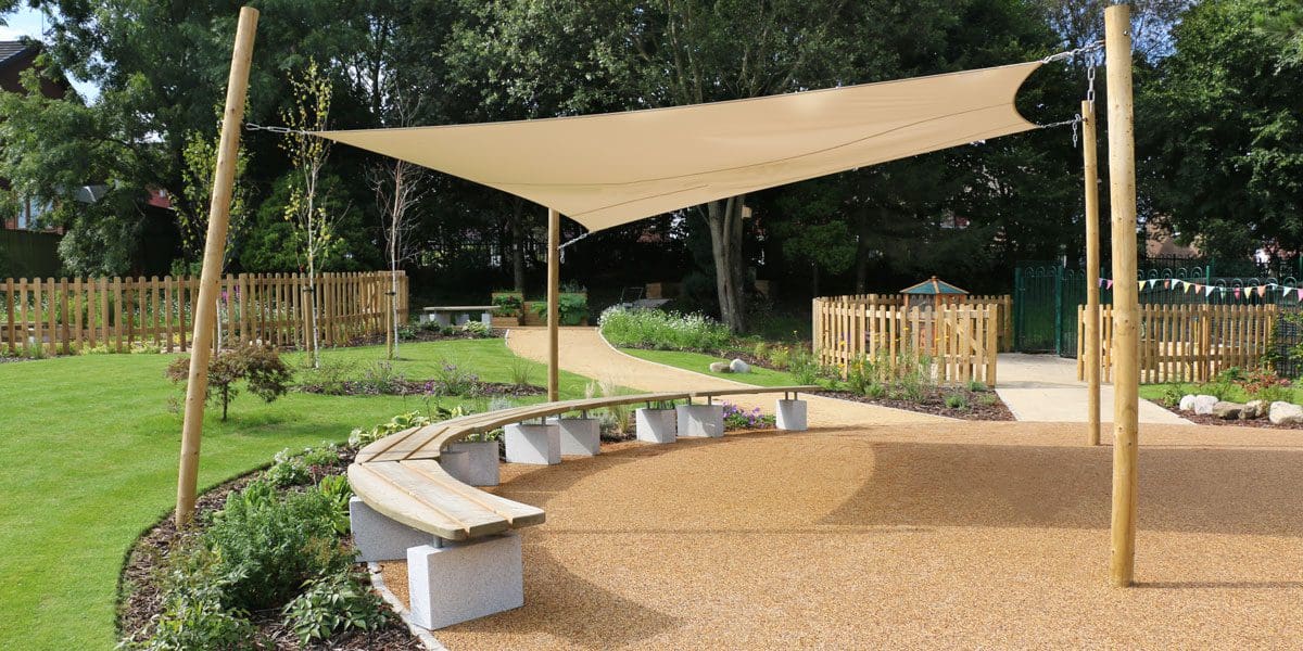 Curved semi circle of wooden benches with concrete plinth legs under stretch canopy from wooden poles