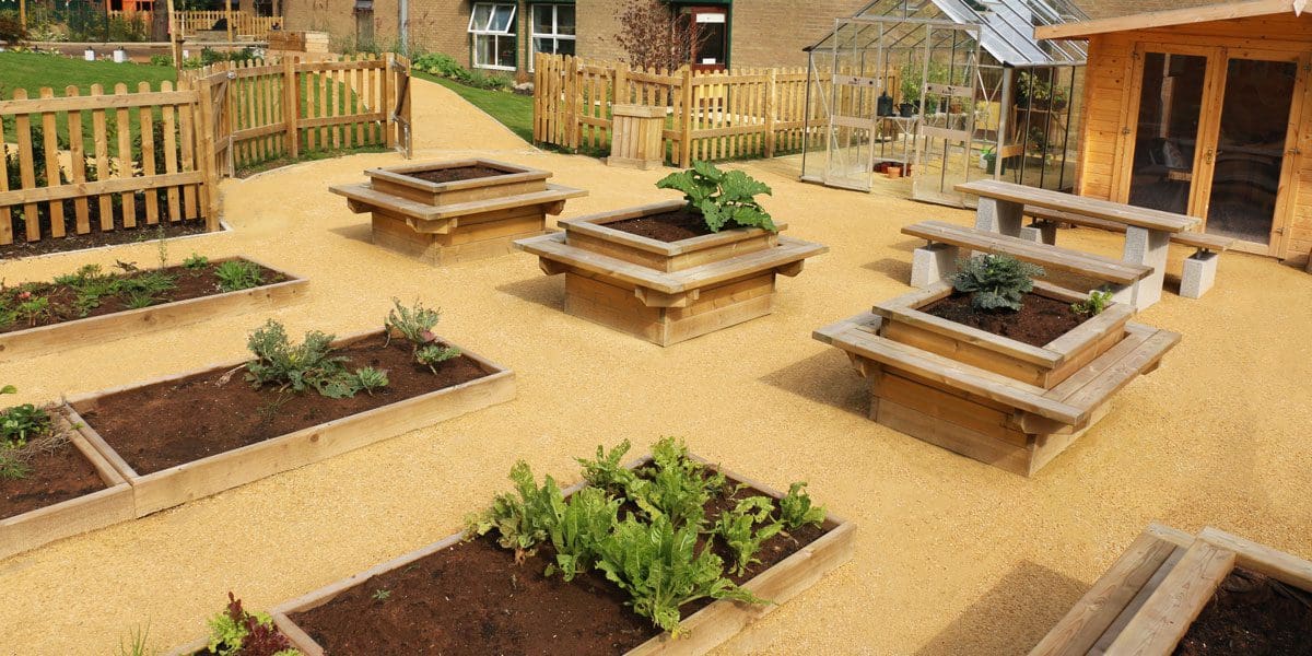 Rows of long raised plant beds and taller square planters with attached seating