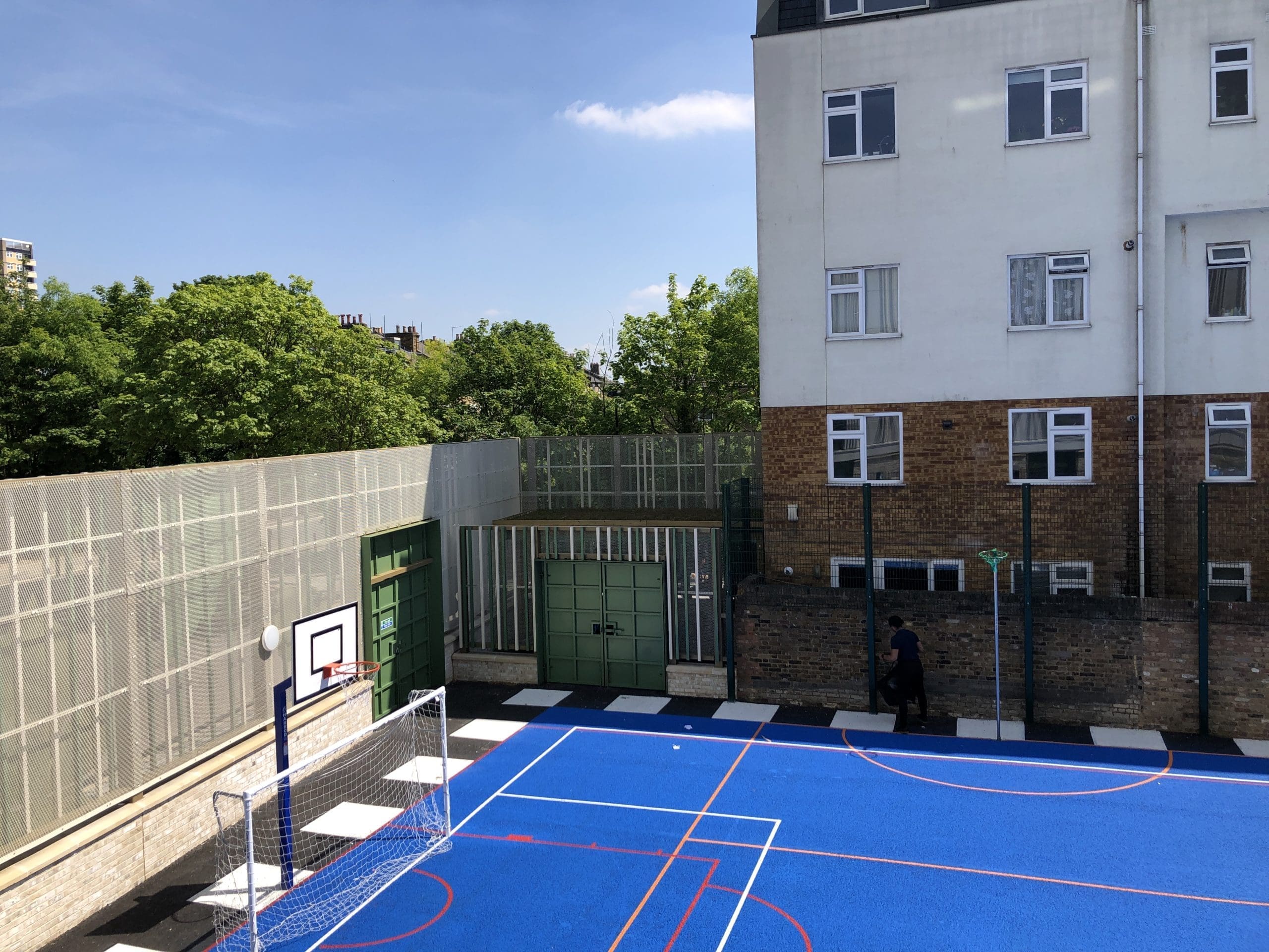 Outdoor wooden canopy green metal doors infront of basketball sports court