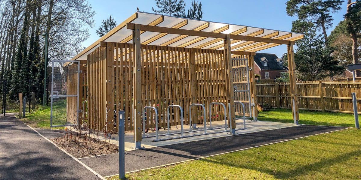 Exterior wooden bicycle shelter with inside storage and outside metal bike hoops