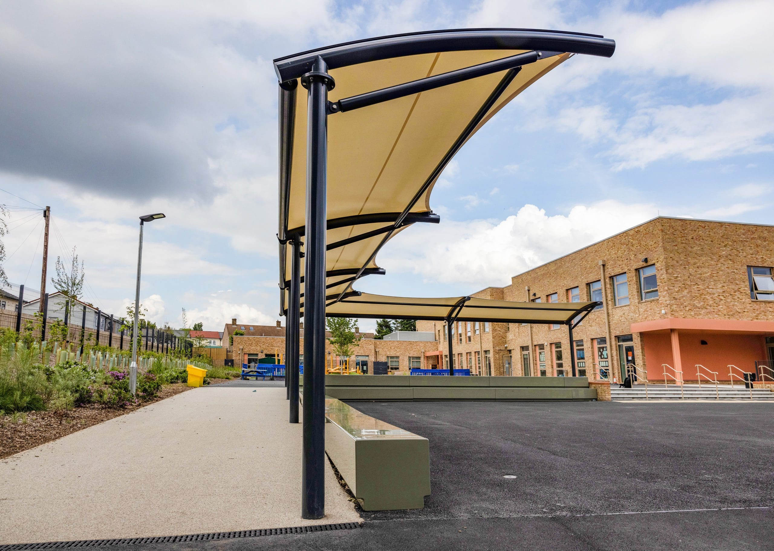 External L shaped stretch fabric and metal pergola covering concrete benches