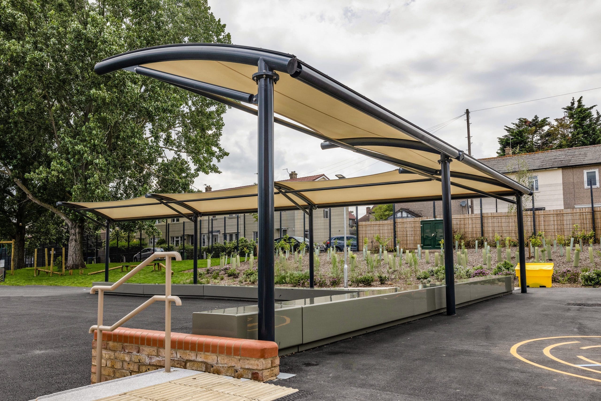 External L shaped stretch fabric and metal pergola covering concrete benches