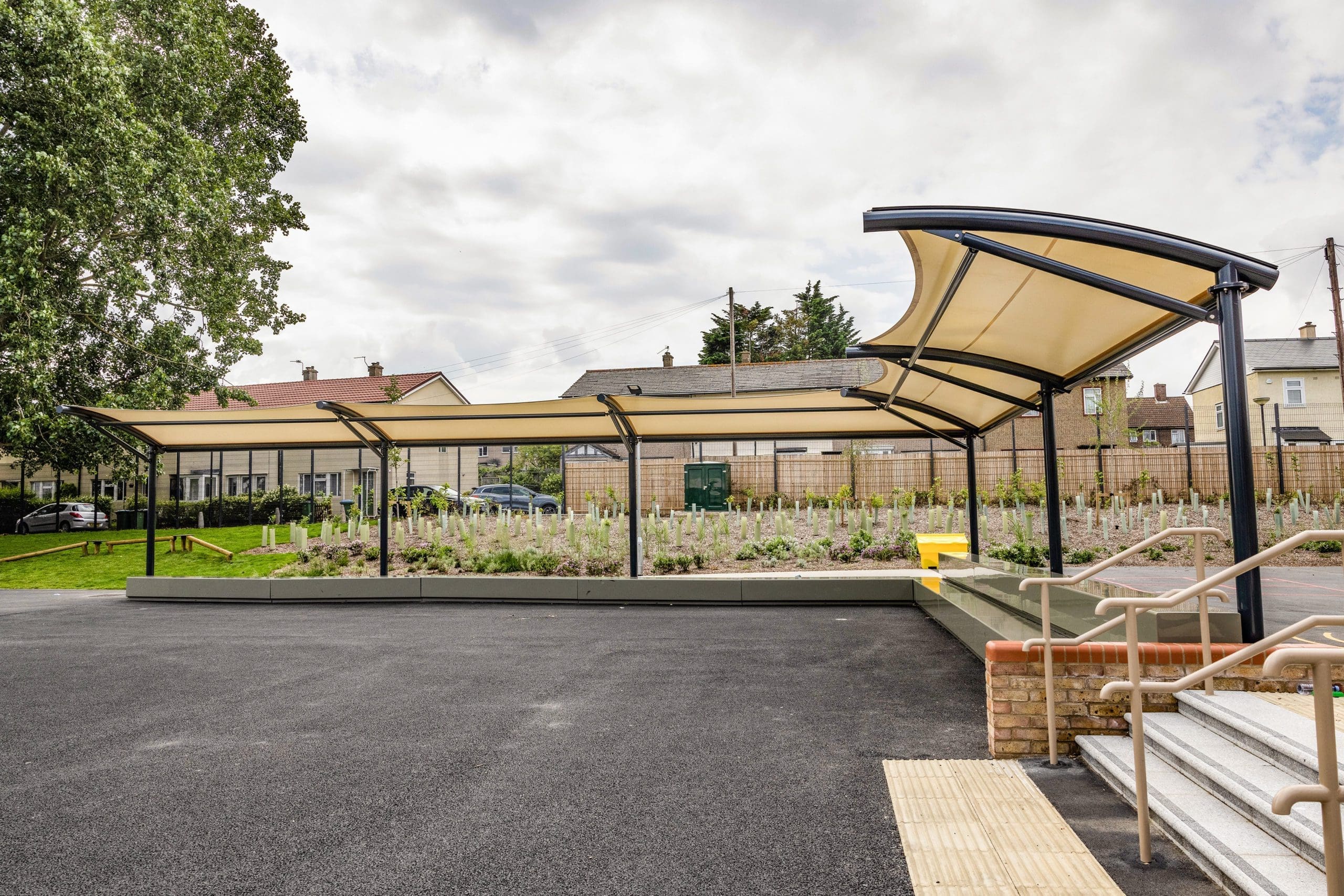 External L shaped stretch fabric and metal pergola covering concrete benches
