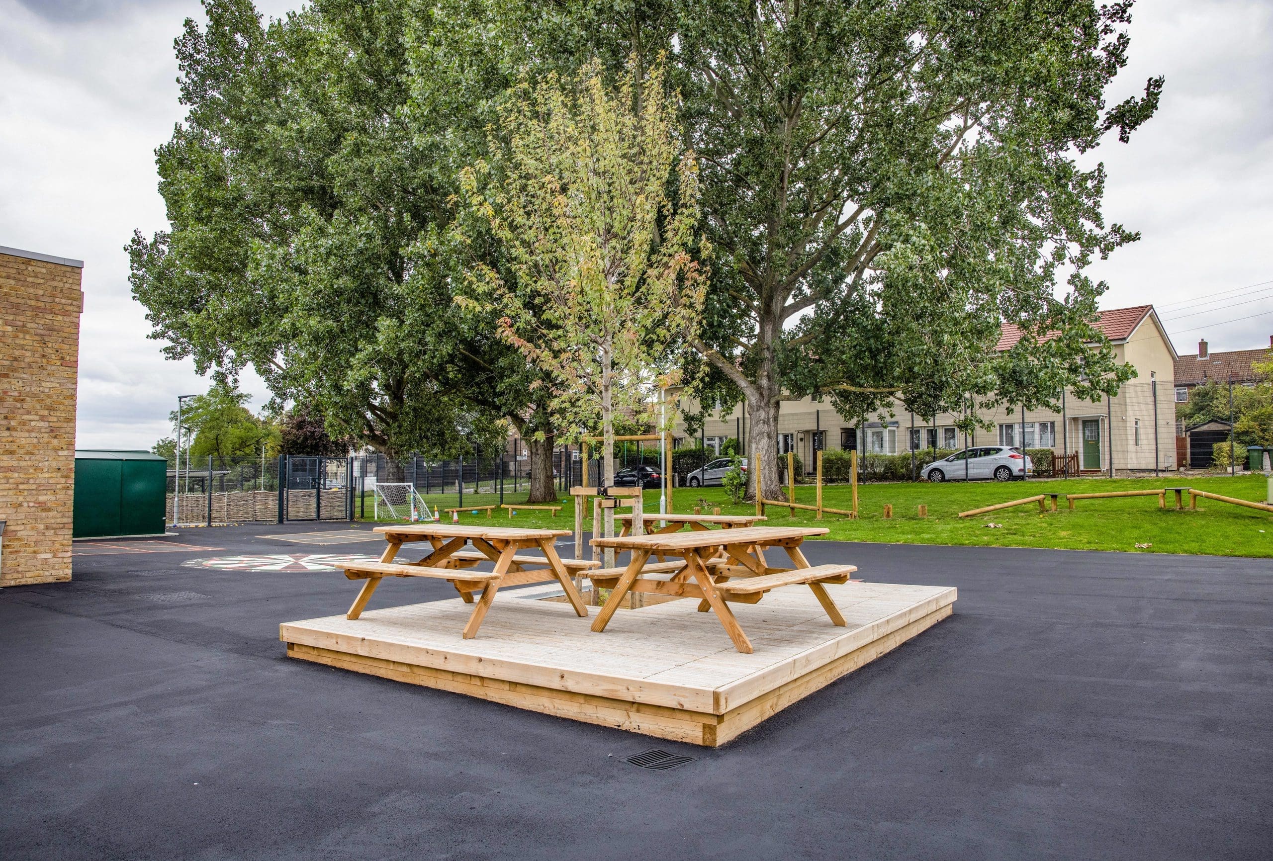 Raised wooden square of decking for picnic benches