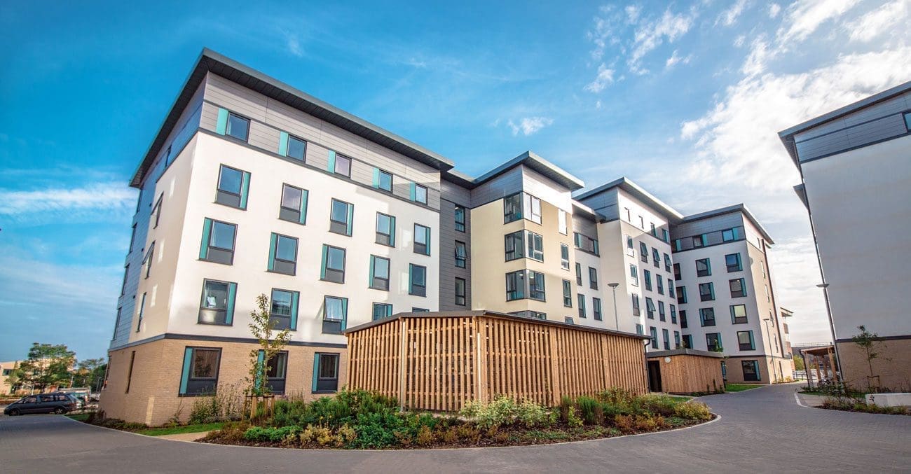 University exterior showing large cycle storage structures infront of tall buildings
